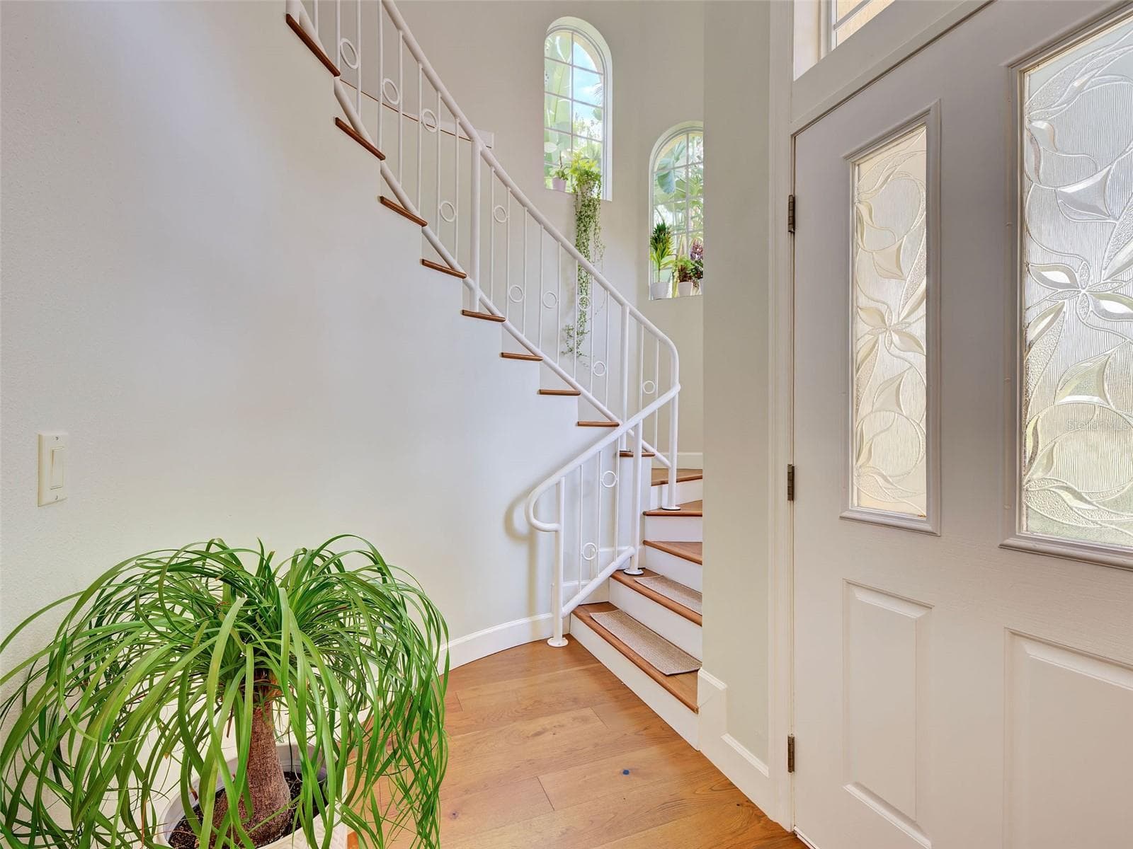 Entering the home, you are greeted with a dramatic staircase to the second floor and beautiful engineered hardwood flooring through the home. - 5026 HANGING MOSS LN, SARASOTA