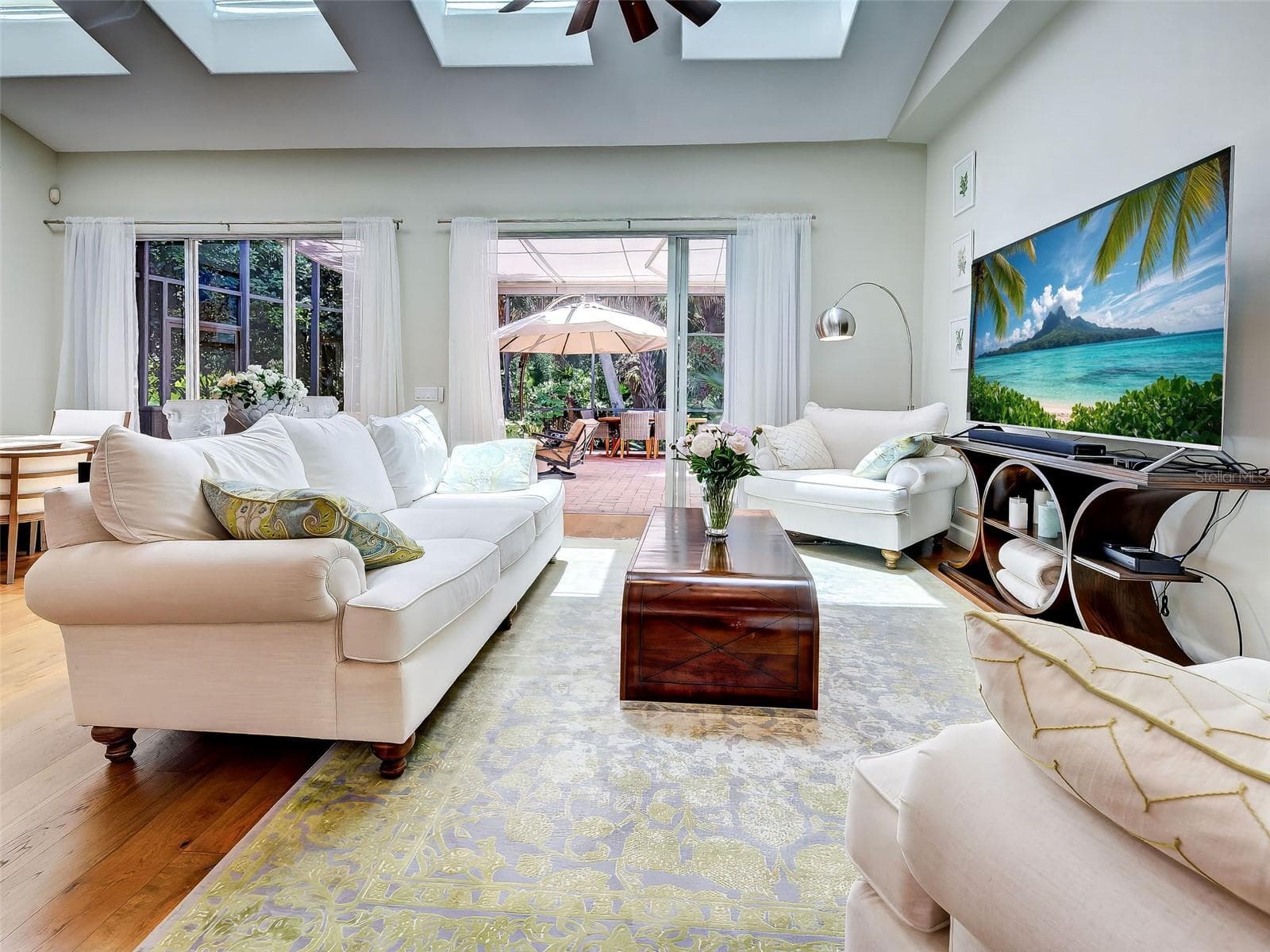 The great room is abundantly bright; accented with skylights and sliding glass doors out to the screened lanai. - 5026 HANGING MOSS LN, SARASOTA
