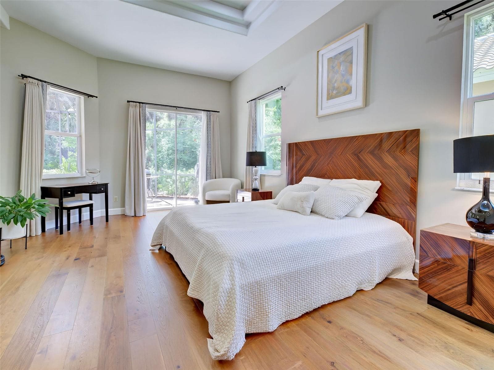 The primary bedroom is located on the first floor with access to the lanai and the en-suite bathroom. - 5026 HANGING MOSS LN, SARASOTA