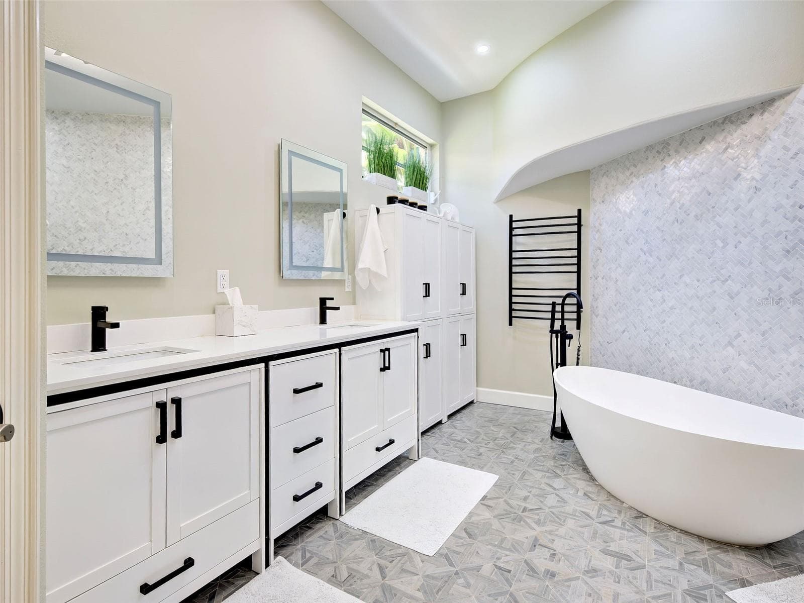 The primary bathroom is light and bright with designer-inspired tiles and double sinks, heated towel racks and cabinets. - 5026 HANGING MOSS LN, SARASOTA