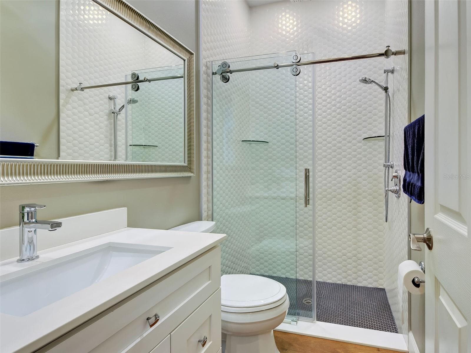 Guest bathroom on the first floor with unique tiles and a walk-in shower. - 5026 HANGING MOSS LN, SARASOTA