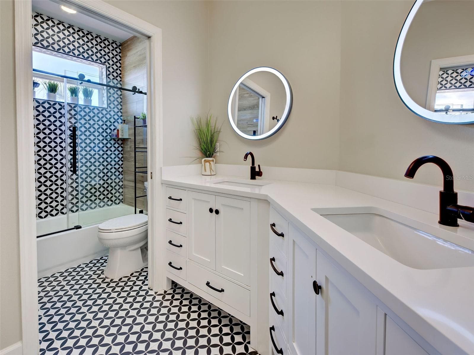 Guest bathroom has double sinks and a tub/shower combination. - 5026 HANGING MOSS LN, SARASOTA