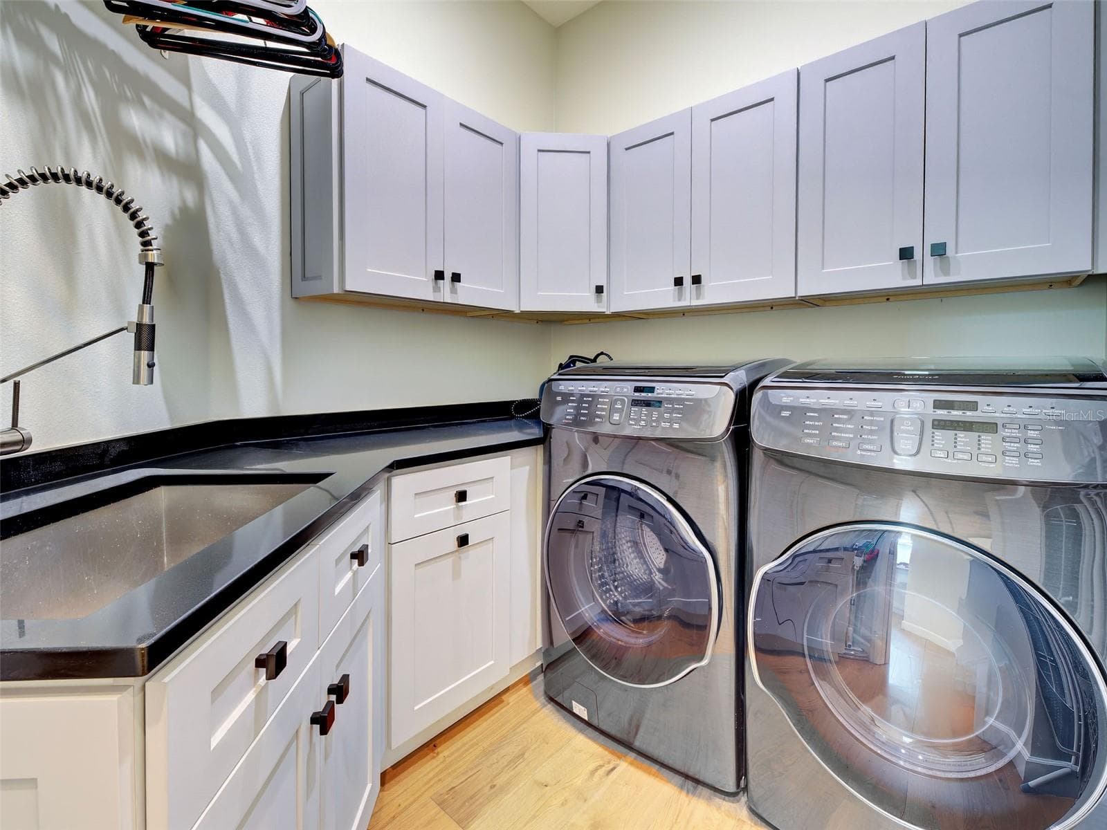The laundry room with cabinets, a sink and Samsung washer and dryer. - 5026 HANGING MOSS LN, SARASOTA