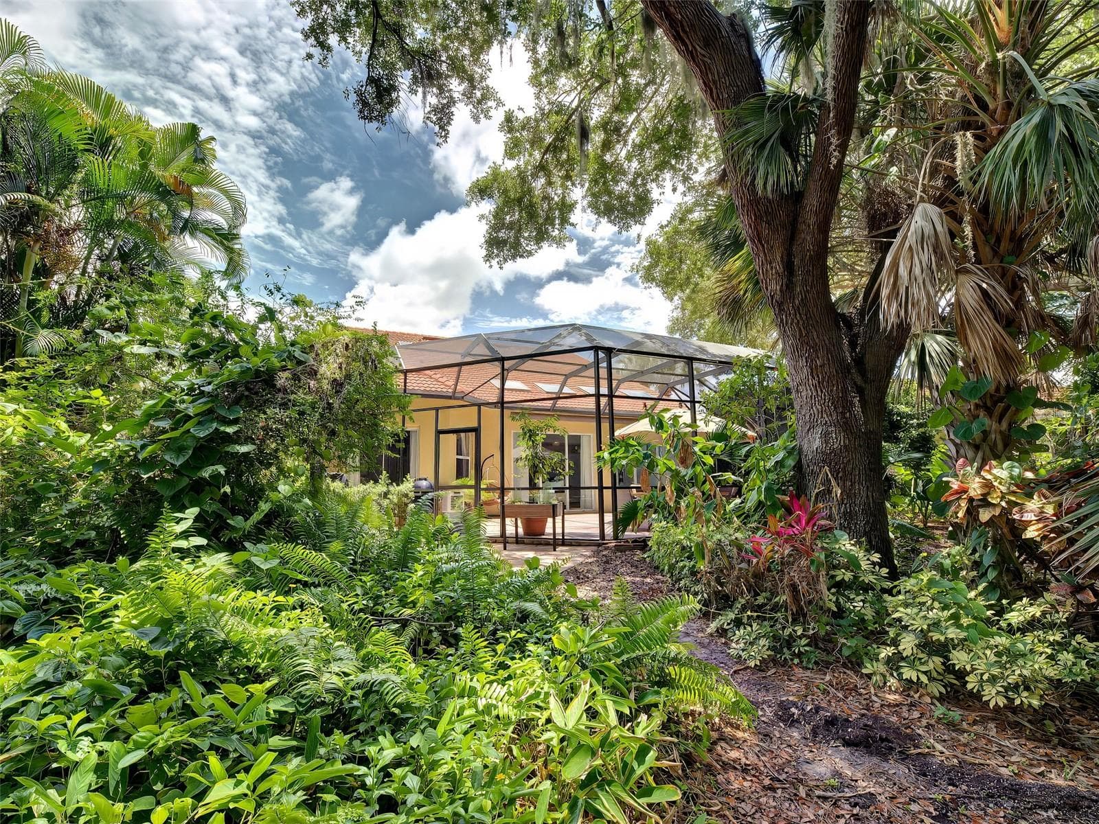 A view from the backyard to the lanai.  Very private and tropical. - 5026 HANGING MOSS LN, SARASOTA