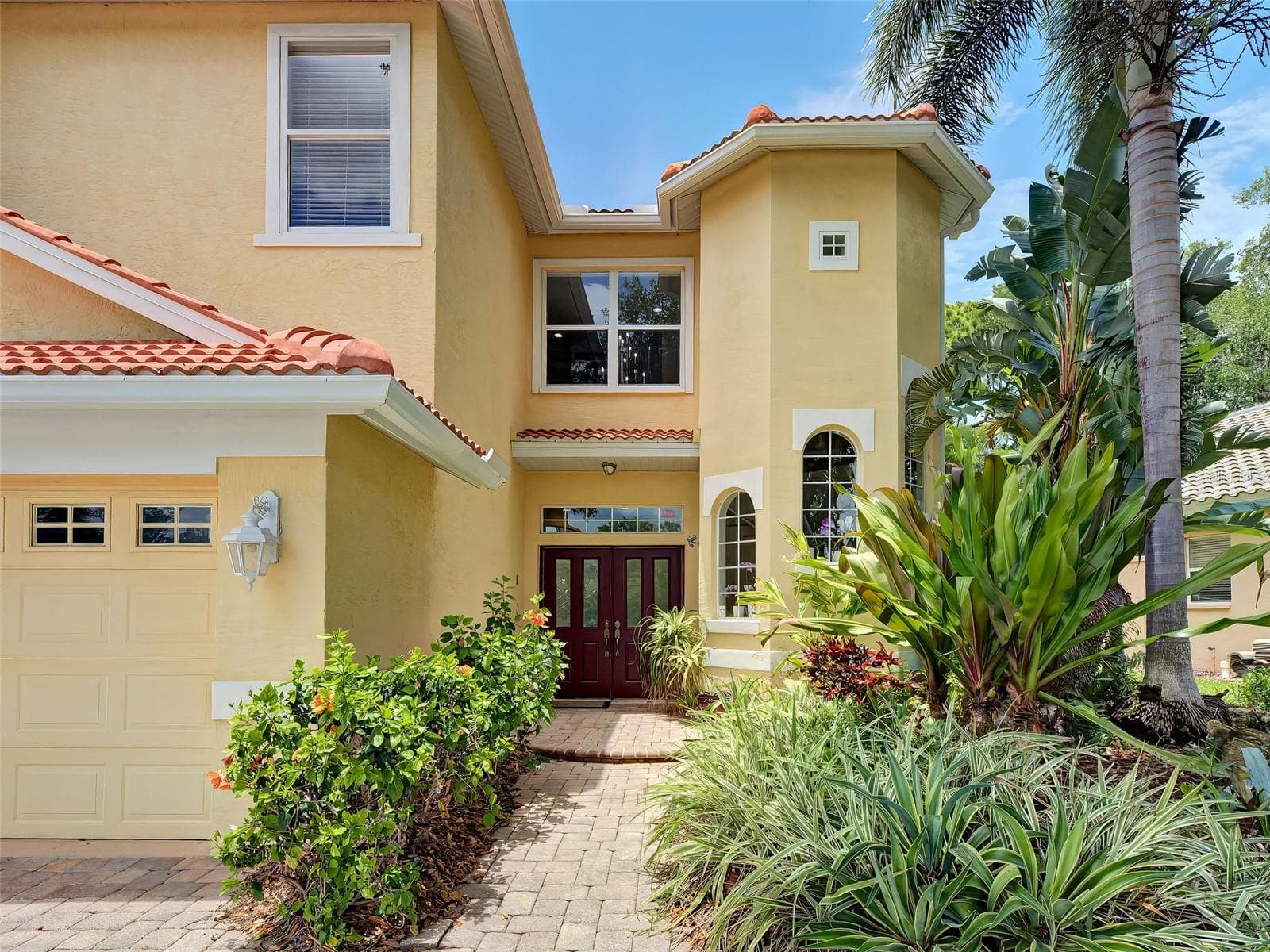 The front entrance has a tasteful double door with detailed glass inserts. - 5026 HANGING MOSS LN, SARASOTA