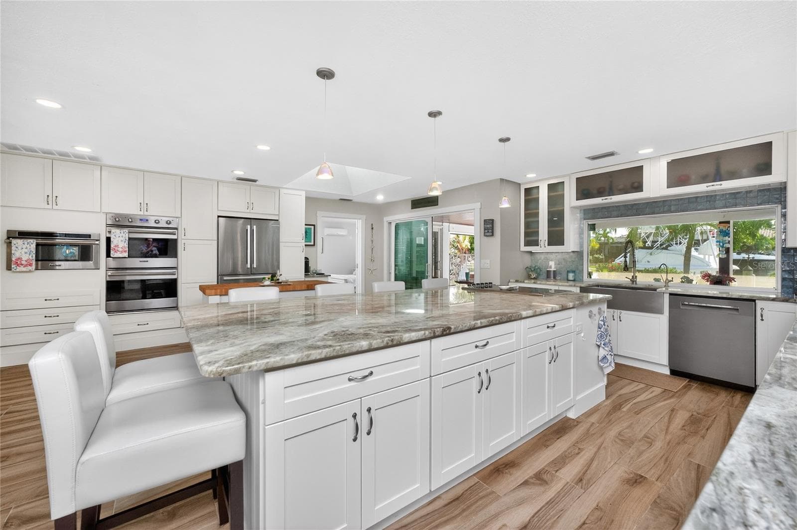 Custom wall cabinetry frames a chef's dream lineup — dual 30" Viking Series 5 wall ovens and microwave, a Bosch French-door beverage-drawer refrigerator, and a Bosch dishwasher. - 80 SABAL DR, PUNTA GORDA