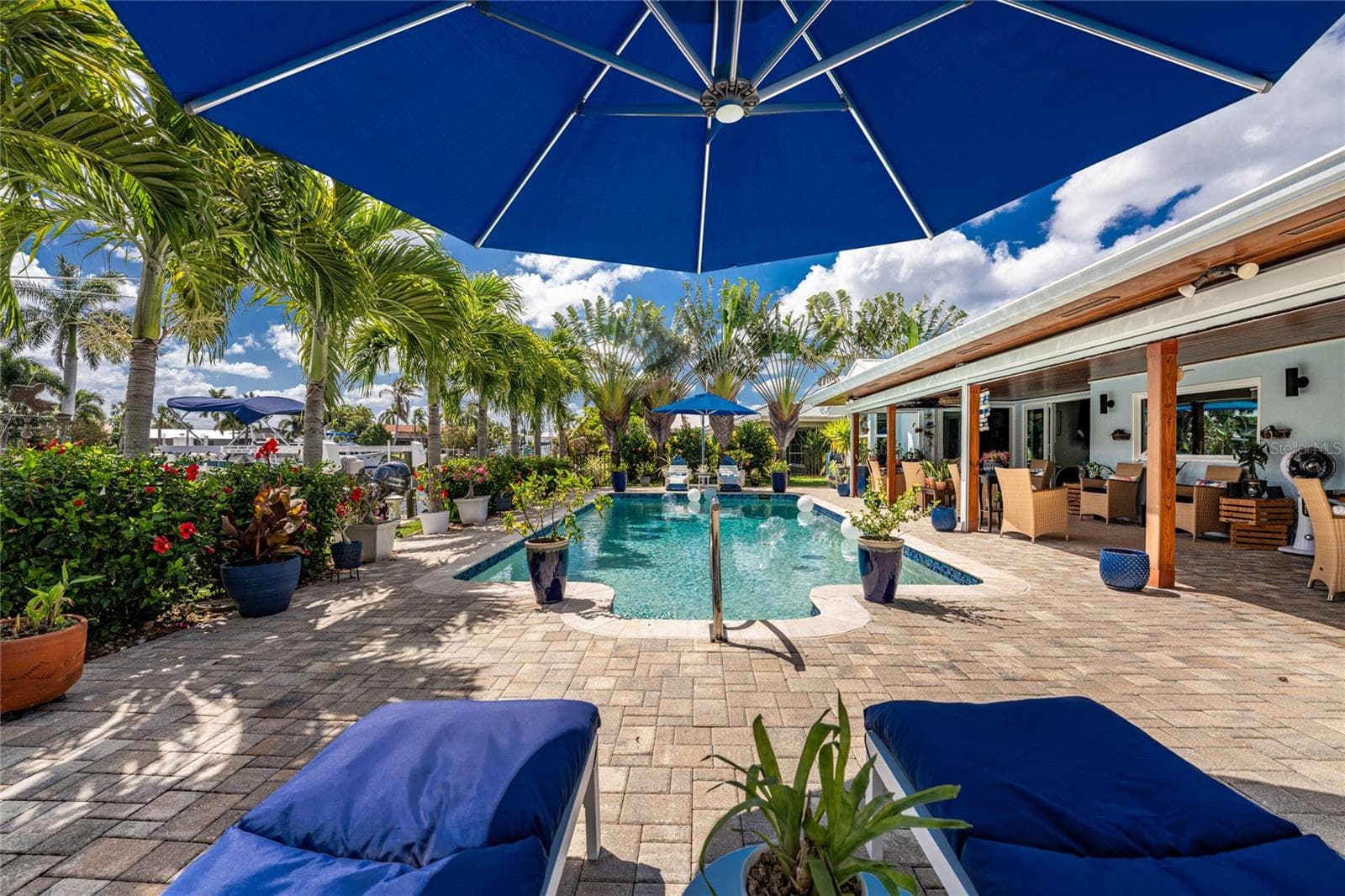 Lush tropical landscaping — towering traveller and christmas palms, vivid blooms, and layers of green that make every corner feel like a private resort. - 80 SABAL DR, PUNTA GORDA
