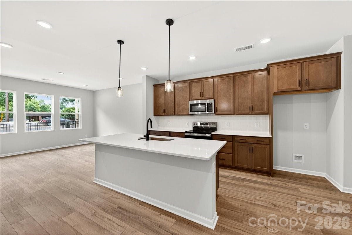 Kitchen with warm brown cabinets paired with white quartz countertops - Charlotte