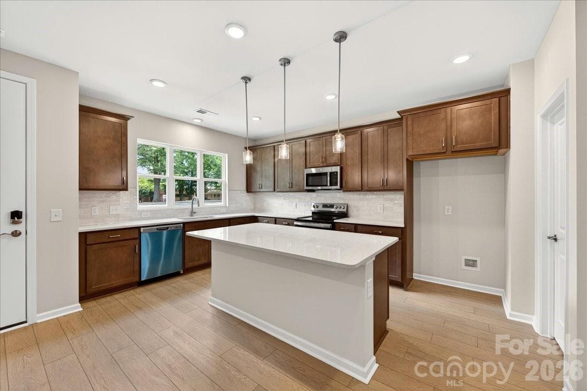 Kitchen with warm brown cabinets and white quartz countertops - Charlotte