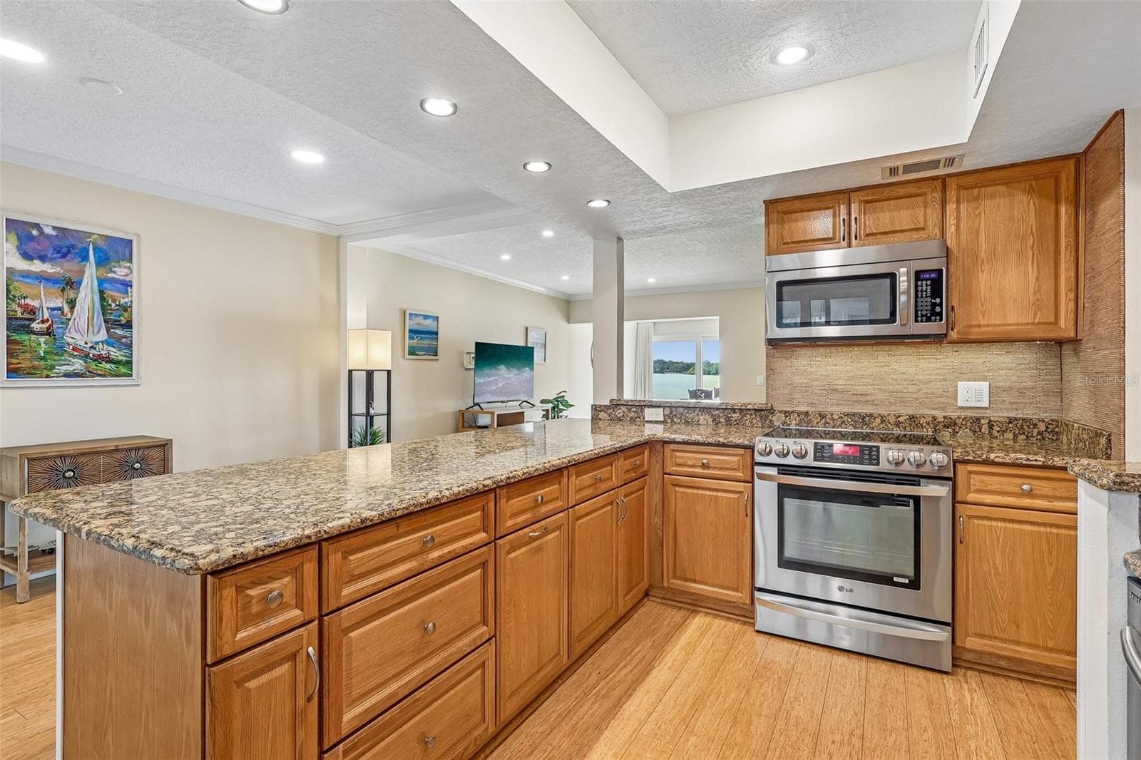 The BEAUTIFULLY UPDATED Kitchen is designed for both everyday living and entertaining, featuring GRANITE COUNTERTOPS, stainless steel appliances, abundant cabinetry, a breakfast nook, a NEW backsplash, and a NEW REFRIGERATOR. - 632 DESOTO DR #632, CASSELBERRY