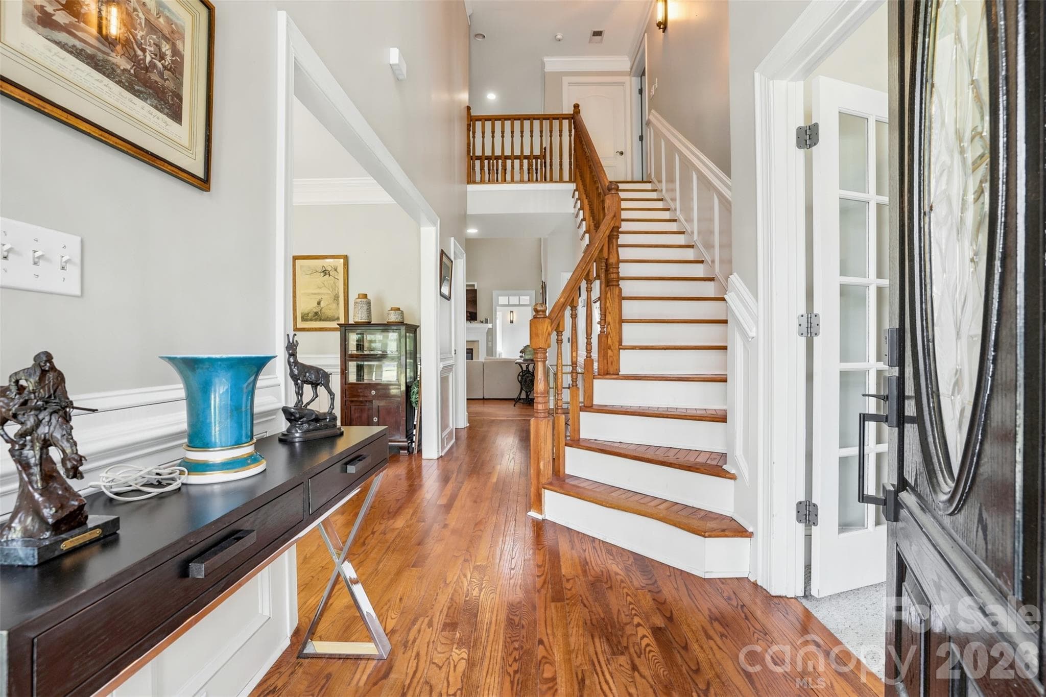 Grand foyer showcases hardwood floors, soaring ceilings, and a striking staircase. - 8520 Stock Horse Trail, Windsor
