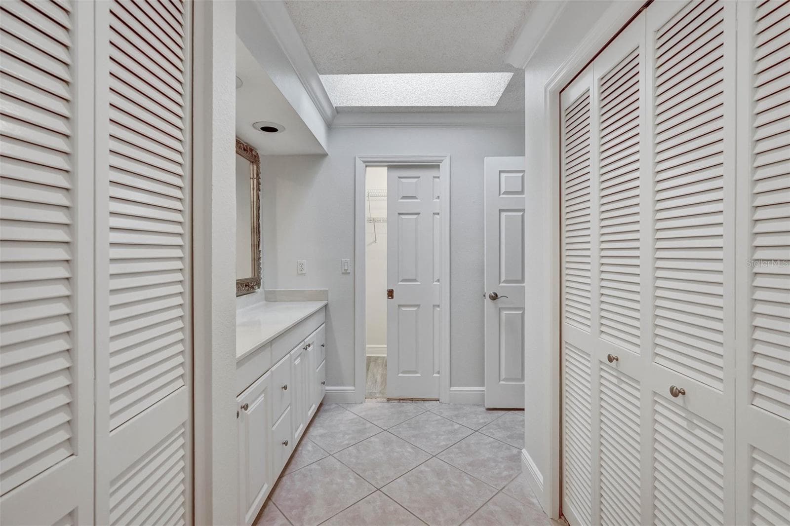 Primary bathroom, walk in closet and vanity - 7861 PINE TRACE DR #7861, SARASOTA