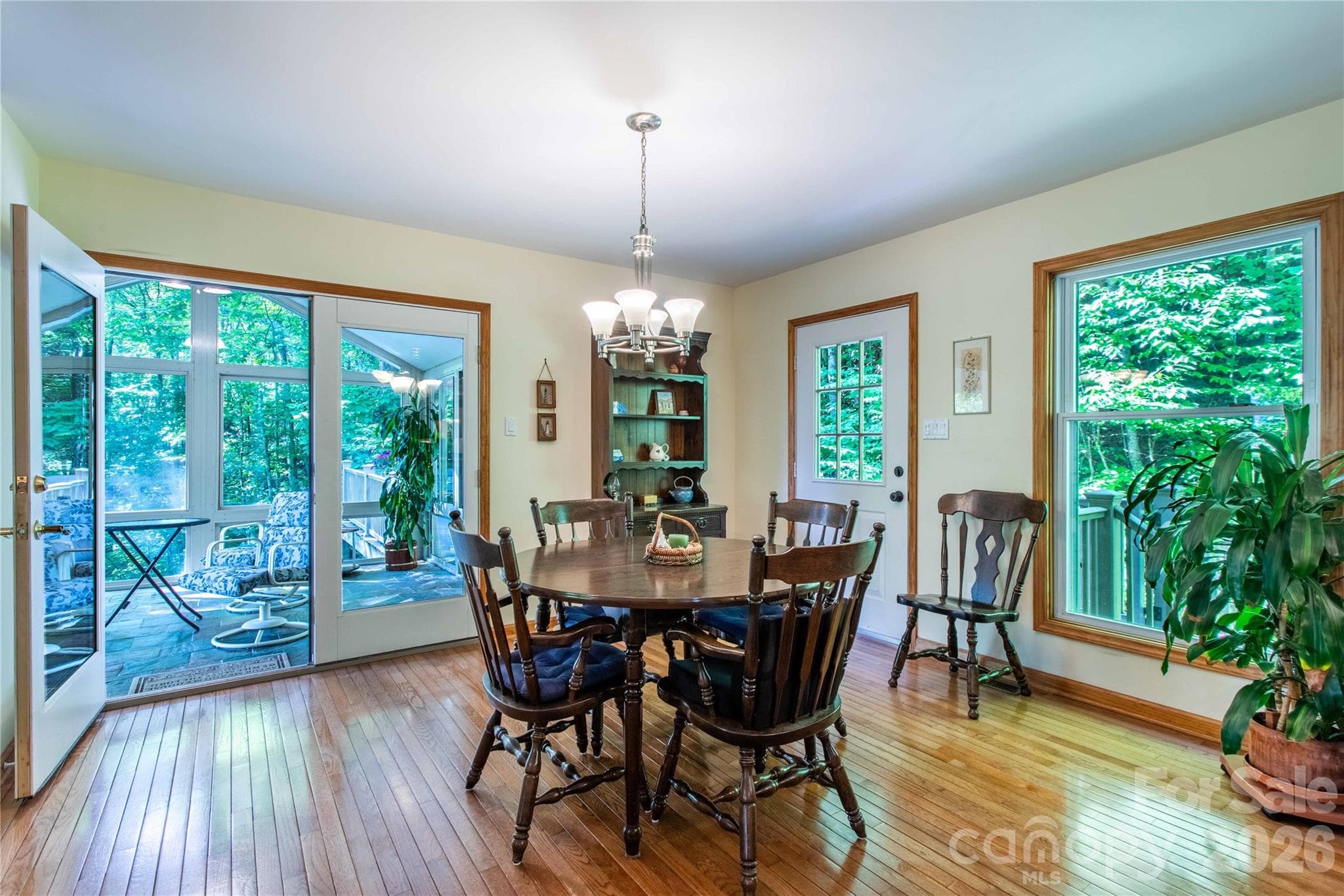 Light-filled dining room with gleaming wood floors off the kitchen and sunroom. - 22 Great Aspen Way, Black Mountain