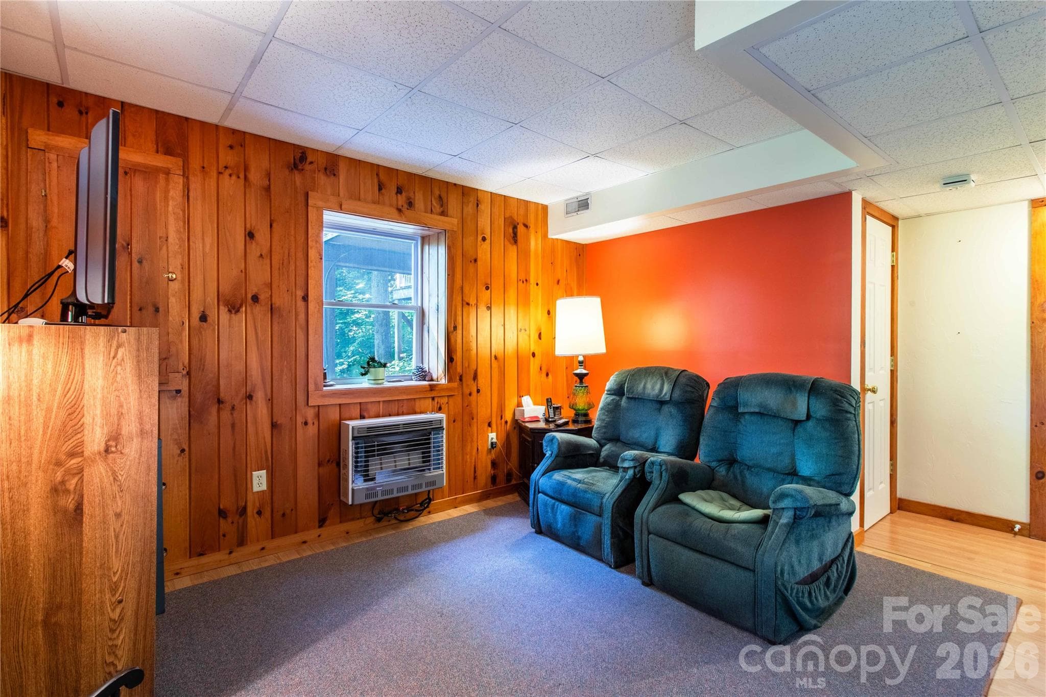 Lower level living area with wood wall accents. - 22 Great Aspen Way, Black Mountain