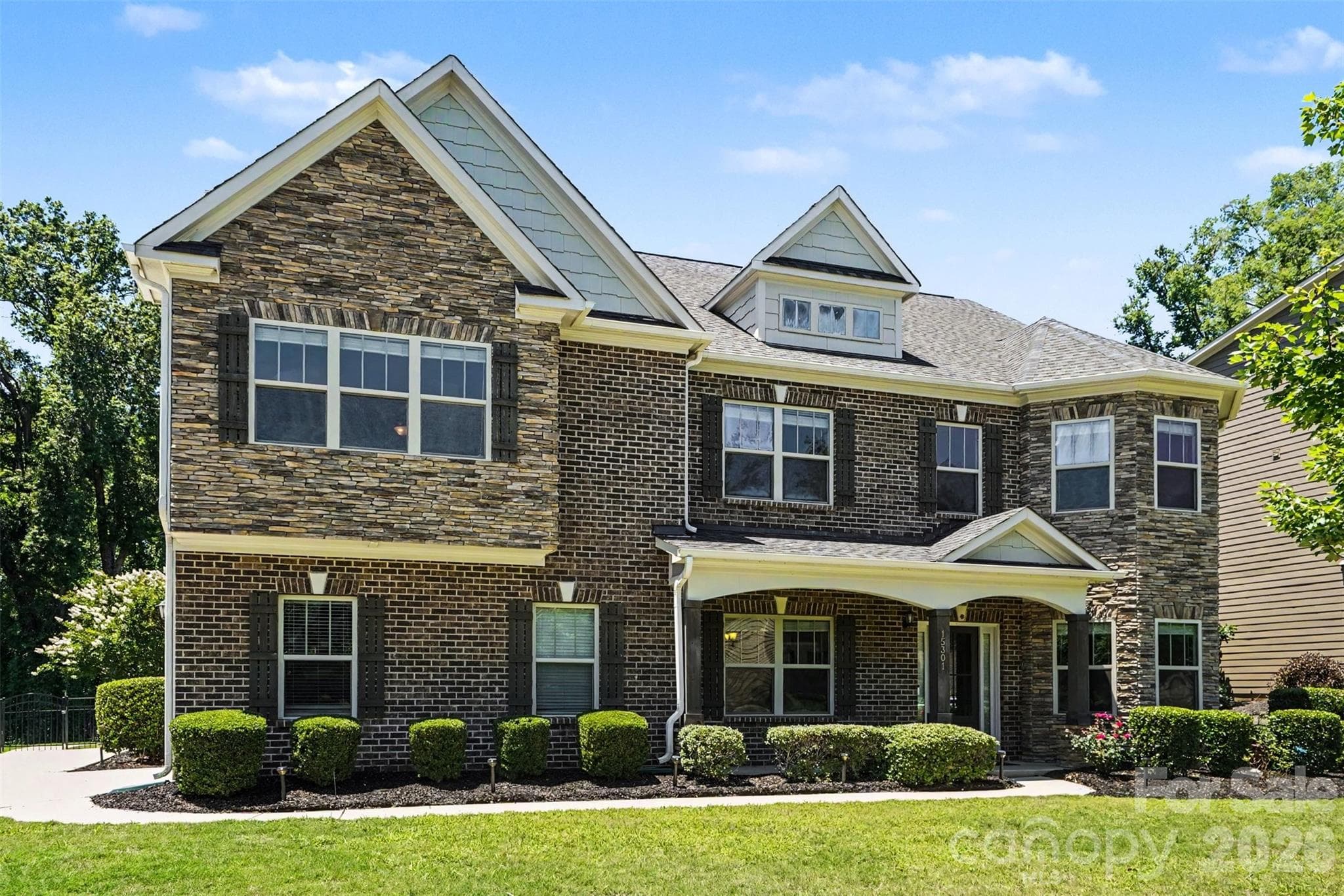 Stone and brick front home with a beautiful, wide front porch. - Huntersville
