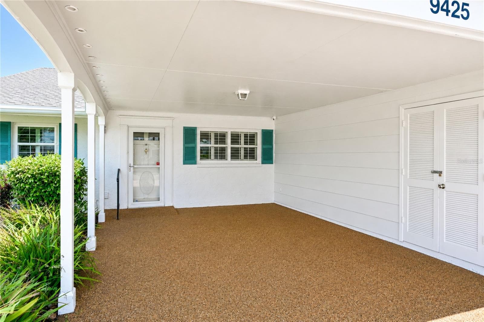 Wide carport with refreshed Polly-Pebble flooring & secure outdoor storage - 9425 ANDOVER CIR, BRADENTON