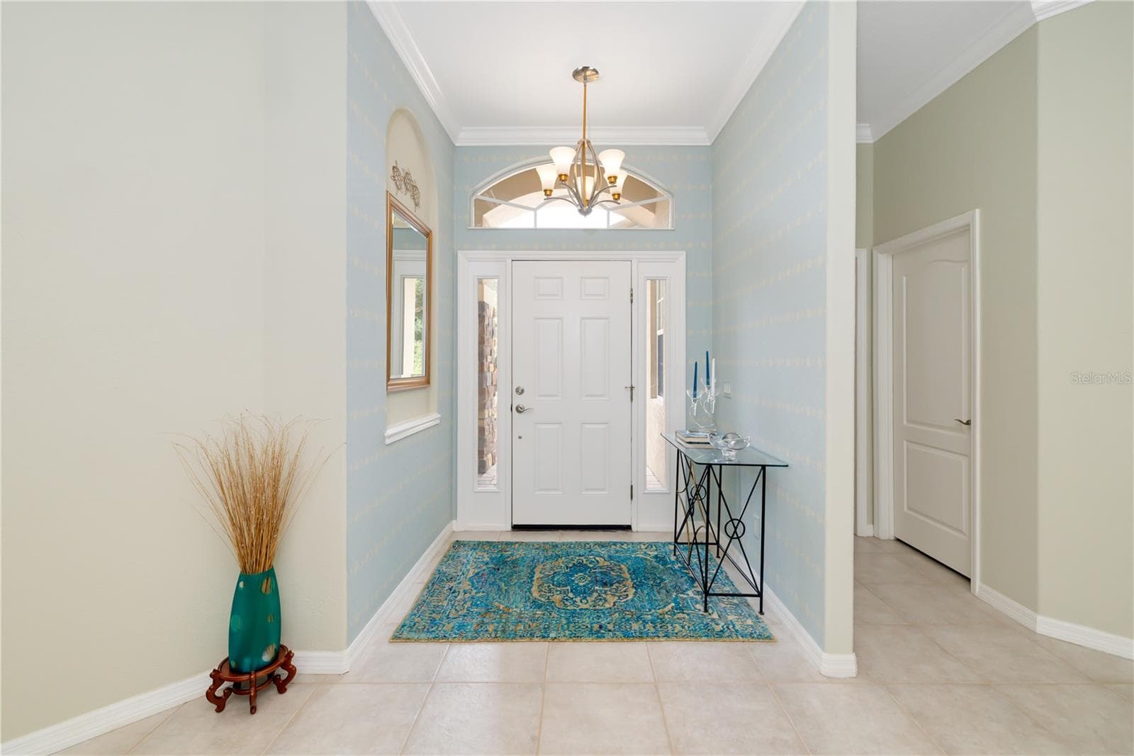 Beautiful, light, bright foyer with crown molding, trey ceiling, modern lighting, welcoming you to the modern updated 5 bedroom heated pool home at 12471 Natureview Circle - 12471 NATUREVIEW CIR, BRADENTON