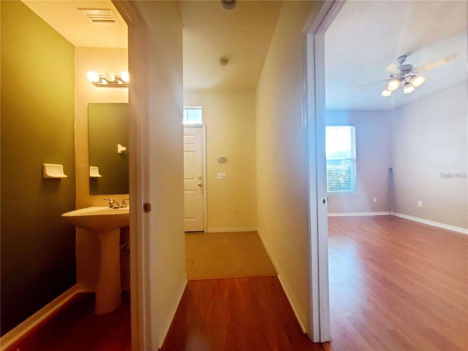 Downstairs hallway 1/2 bath and primary bedroom - 1561 NW 29TH RD #8, GAINESVILLE