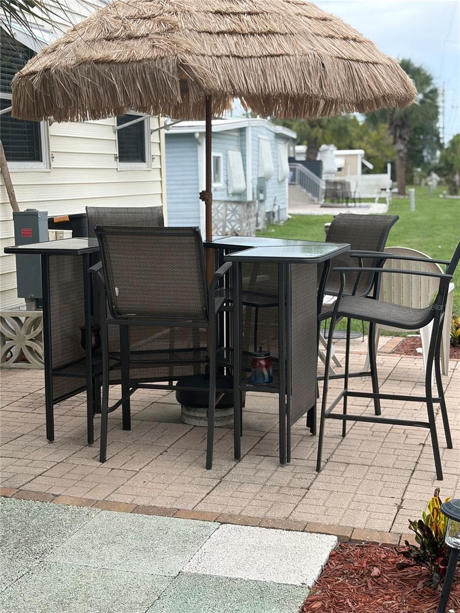 Patio to the rear of the home with bar area. Thatch umbrella to quiet the sunshine. - 723 ROMA RD, VENICE