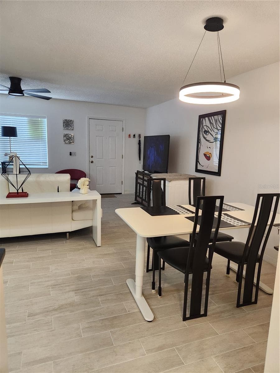 Open concept dining room, living room & kitchen with new tile floors throughout - 9101 W HILLSBOROUGH AVE #I209, TAMPA