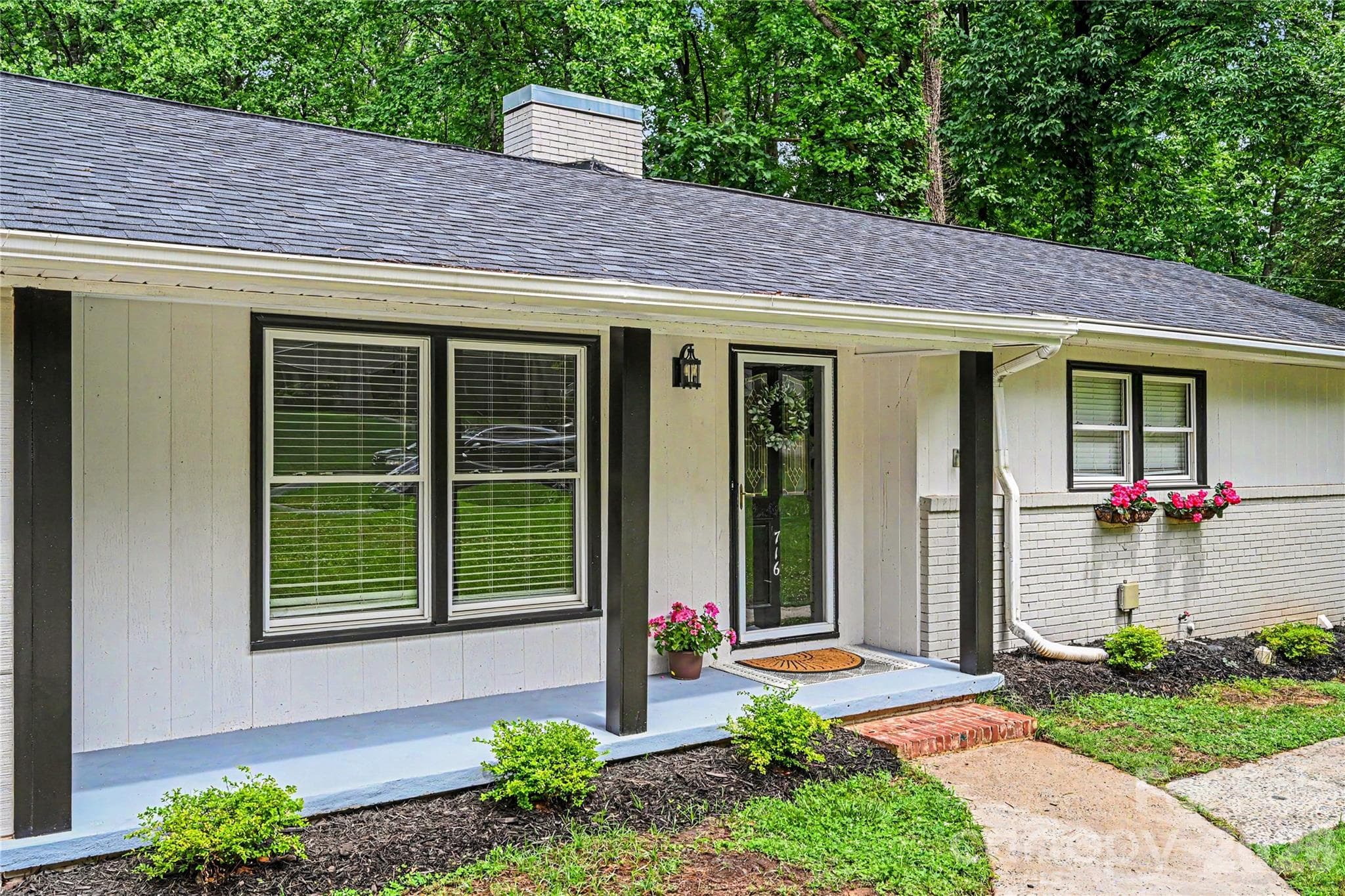 Inviting covered front porch with updated landscaping and classic curb appeal. - Concord