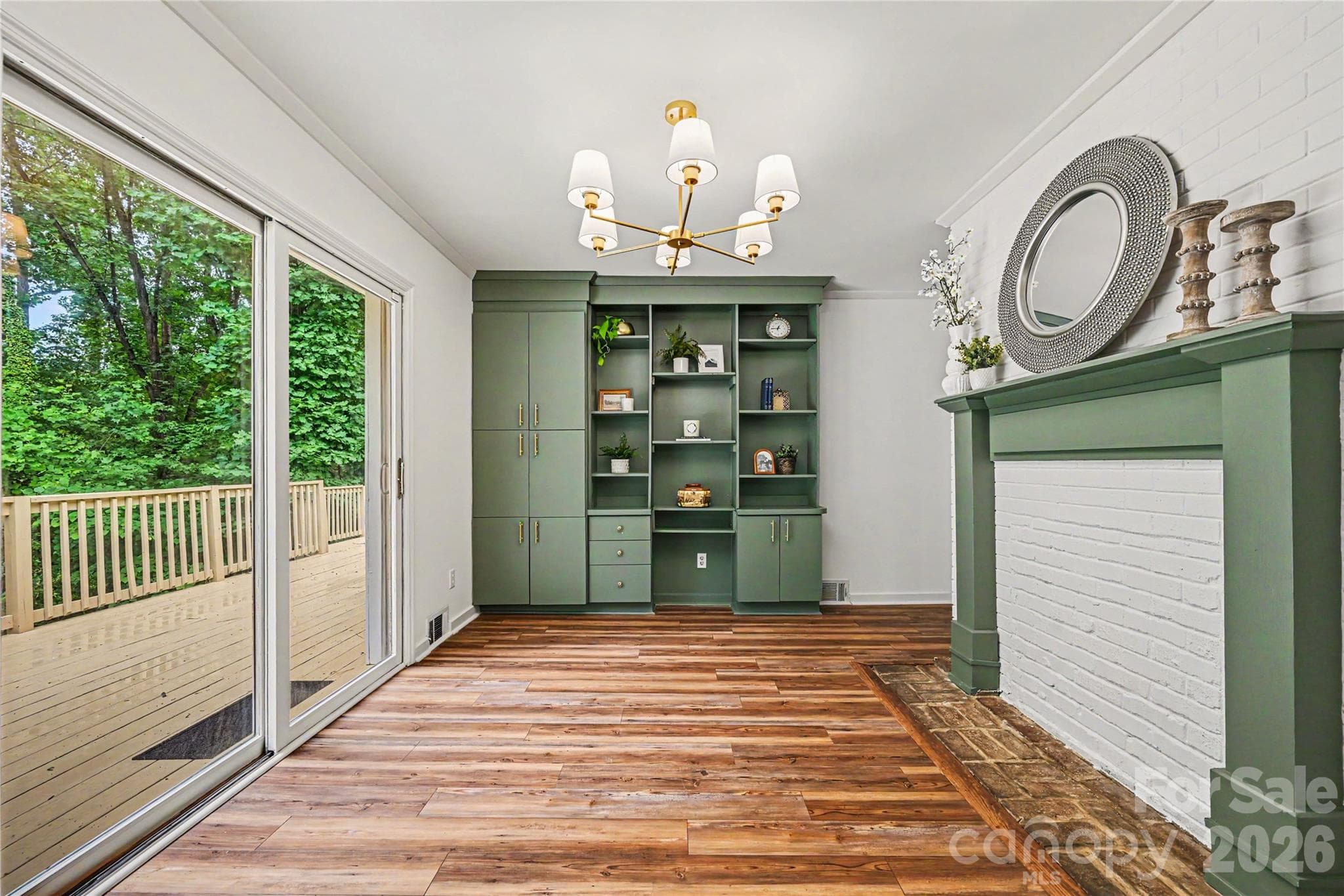 Dining area features custom built in storage and display shelving, a decorative fireplace, and direct access to the expansive deck. - Concord