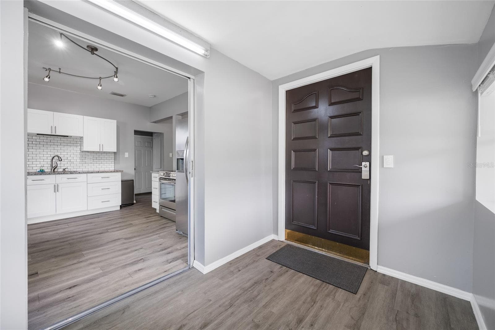 Front door opens into Foyer / mudroom with W/D, large shelf, and has a pocket door to keep noise down. - 5044 BETTY ST N, ST PETERSBURG