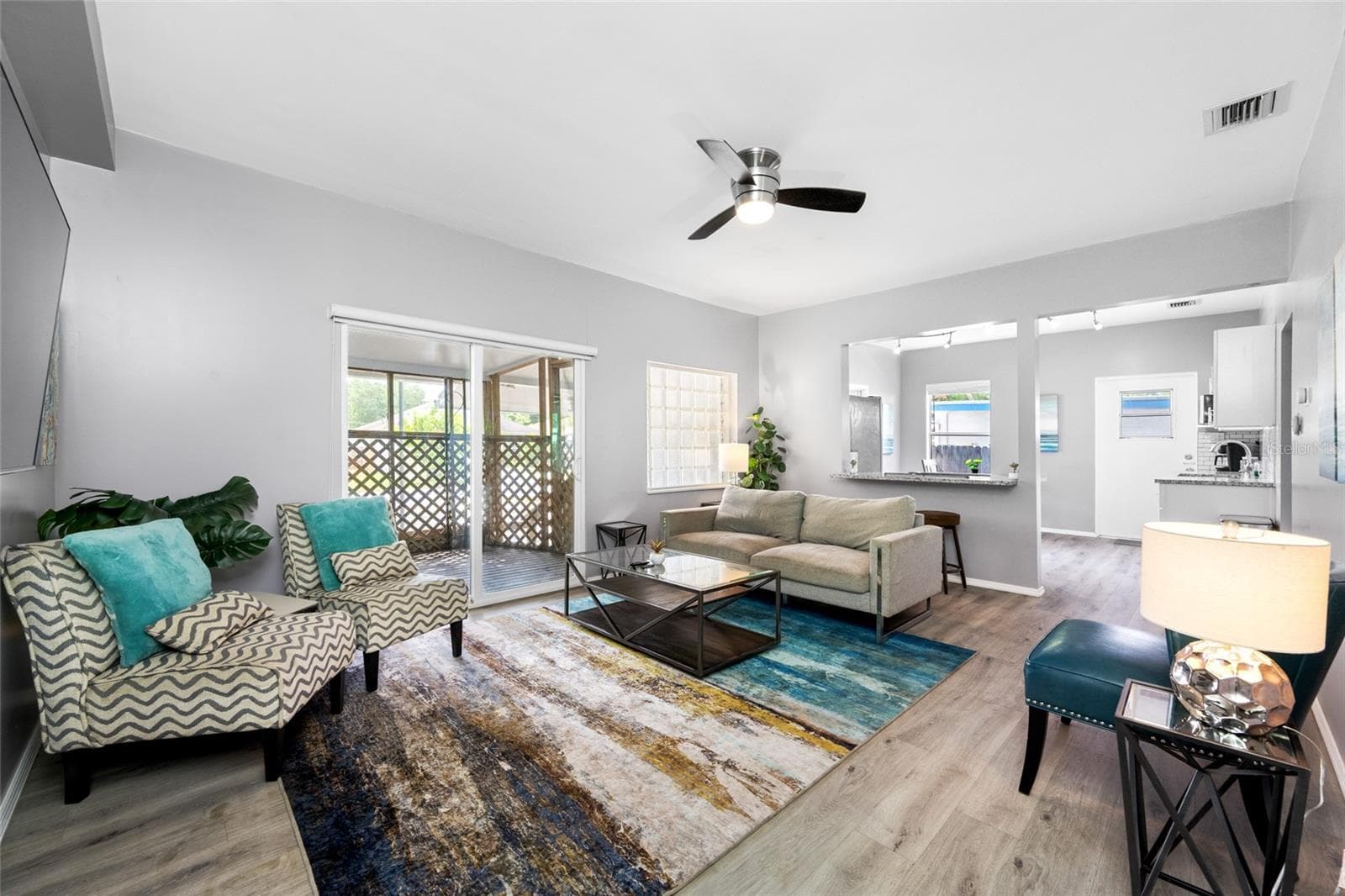 Living Room with electric fireplace and sliding door to the front screened porch - 5044 BETTY ST N, ST PETERSBURG