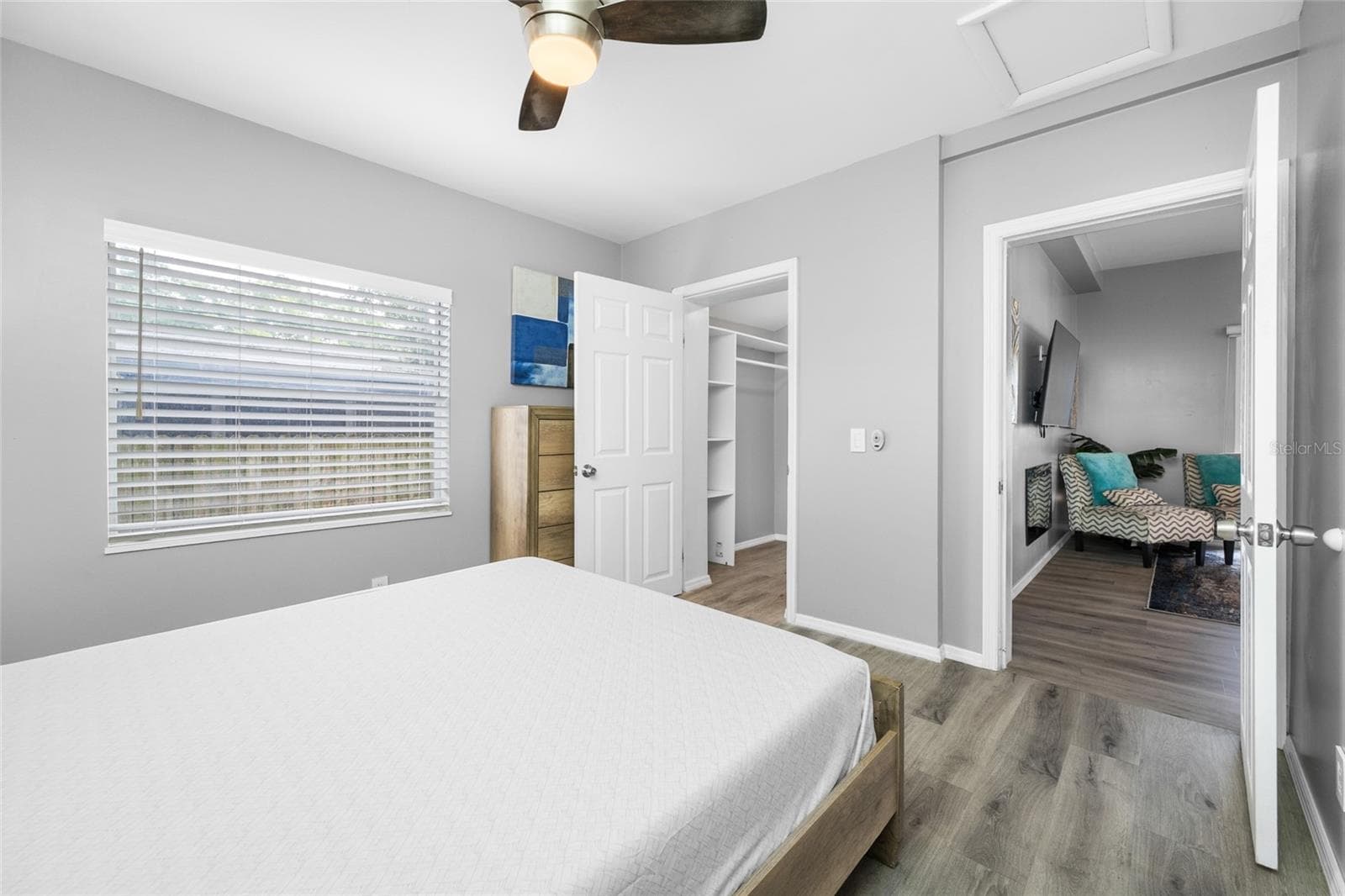 Primary Bedroom suite with walk-in closet, with built in shevles, that opens through to private en-suite updated bathroom with marble tile and glass shower. - 5044 BETTY ST N, ST PETERSBURG