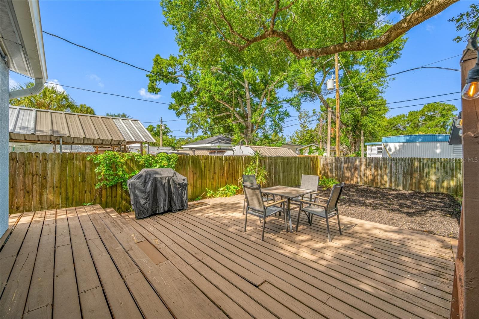 Fenced in back yard with 20ft wide deck that leads to detached workshop and shed. - 5044 BETTY ST N, ST PETERSBURG