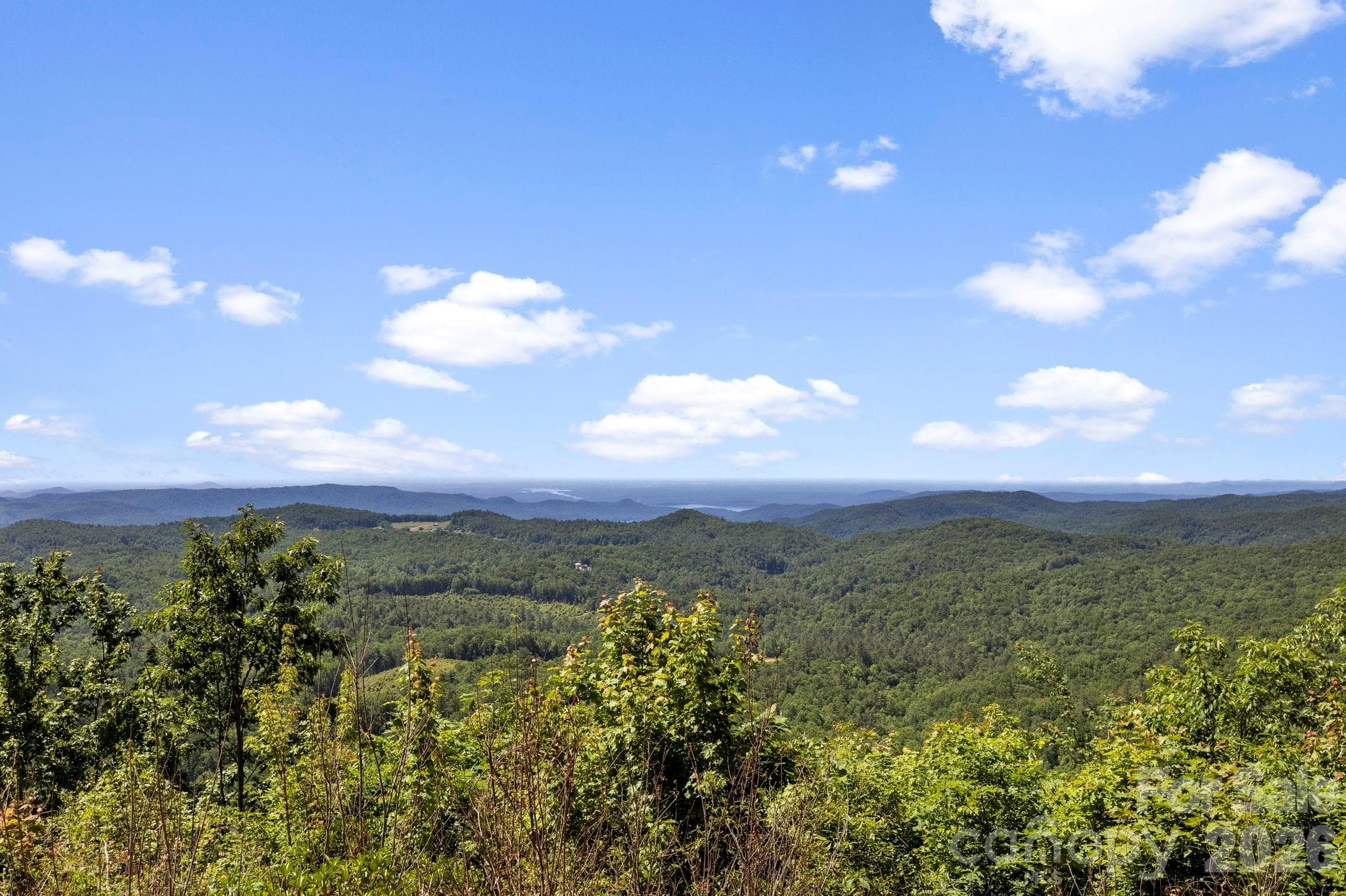 Enjoy sweeping views of rolling hills and forested ridgelines, showcasing the property's exceptional mountain setting. - Lake Toxaway