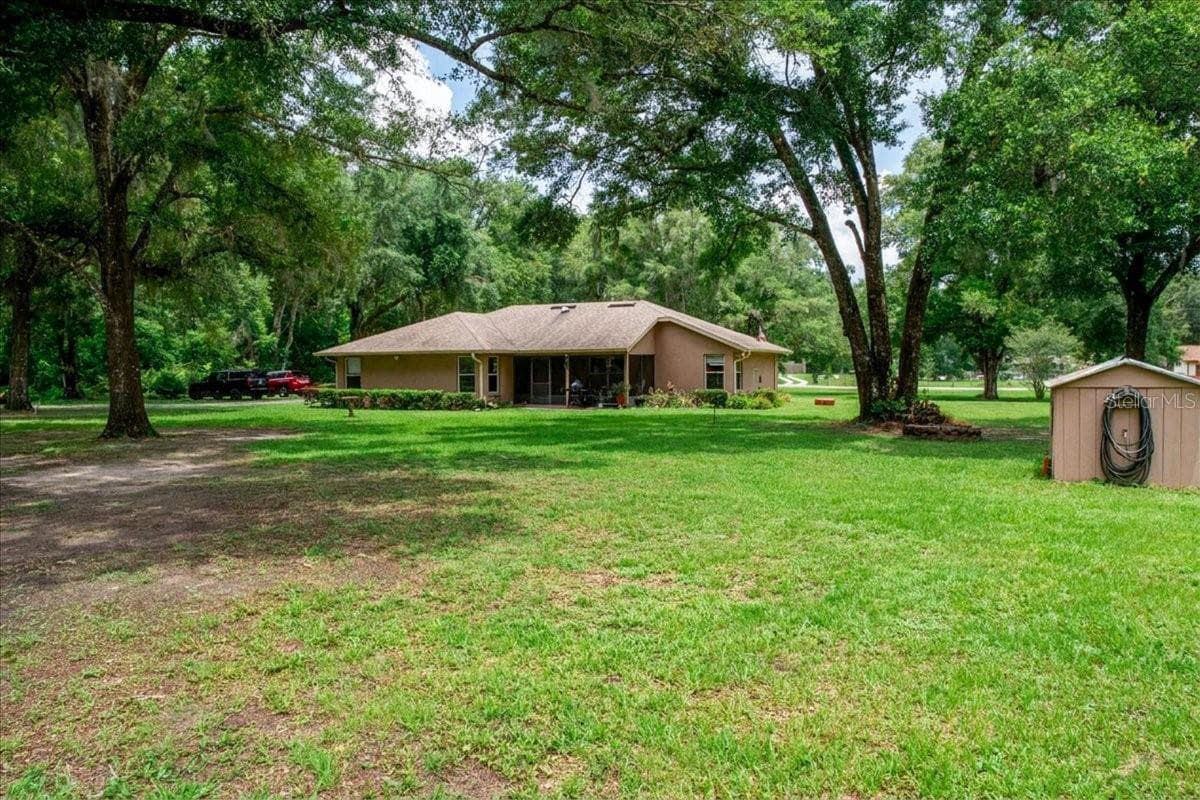 Rear yard view featuring open green space and Well house building for irrigation. - 267 N ORANGE AVE, LAKE HELEN