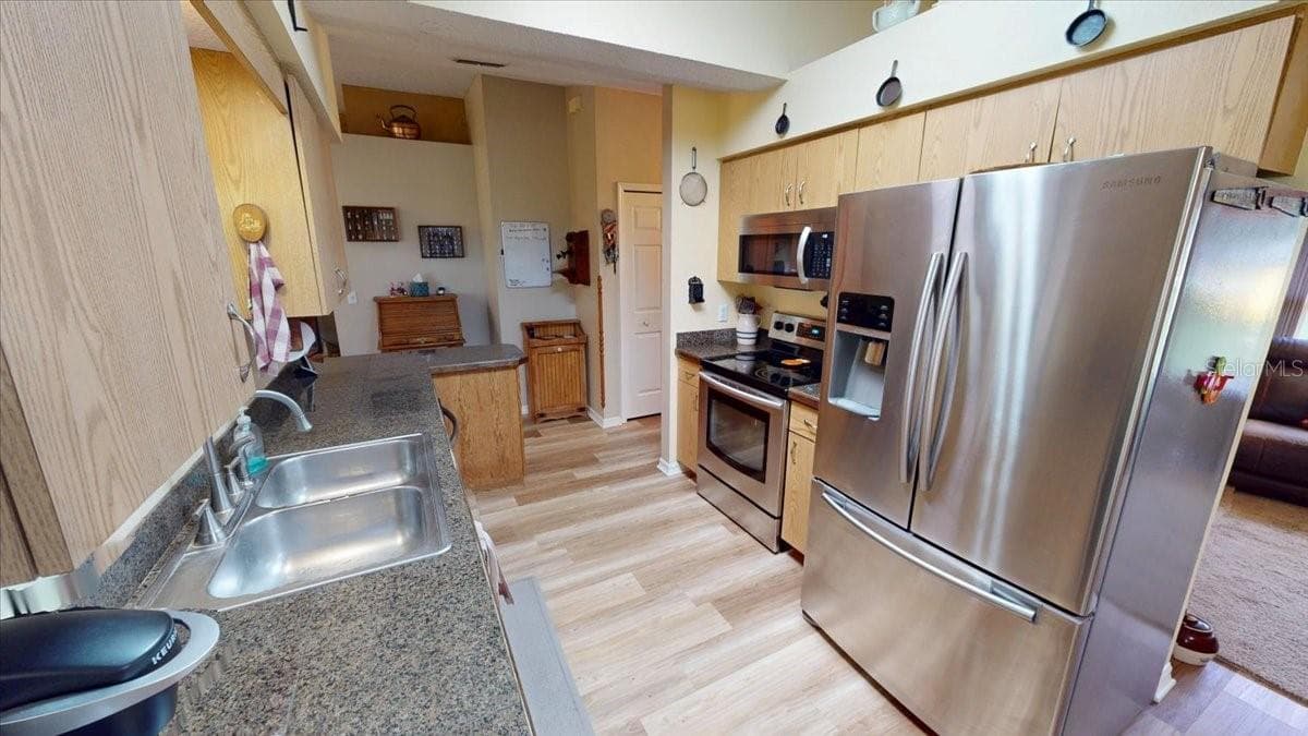 Kitchen featuring stainless steel appliances, ample cabinetry, and workspace. - 267 N ORANGE AVE, LAKE HELEN