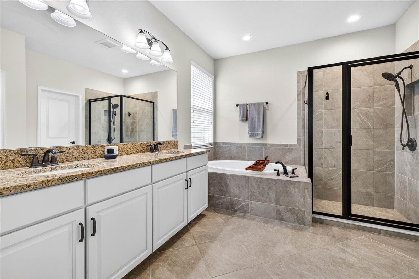 First floor full bath in the primary suite - 7109 BAY LAUREL CT, WESLEY CHAPEL
