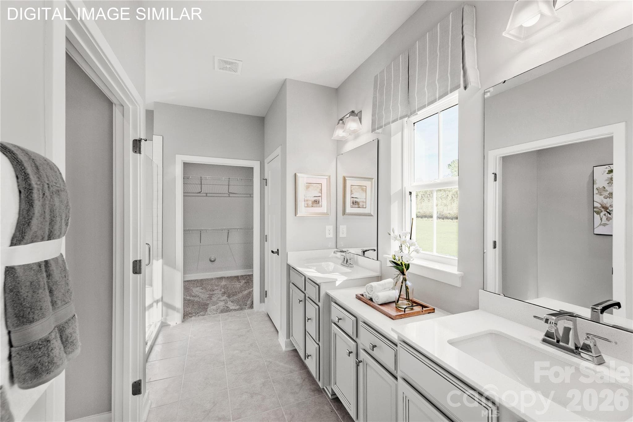 Bright primary bath with dual vanities, walk-in shower, and a spacious walk-in closet for everyday ease. - 11161 Emerson Landing Drive, Charlotte