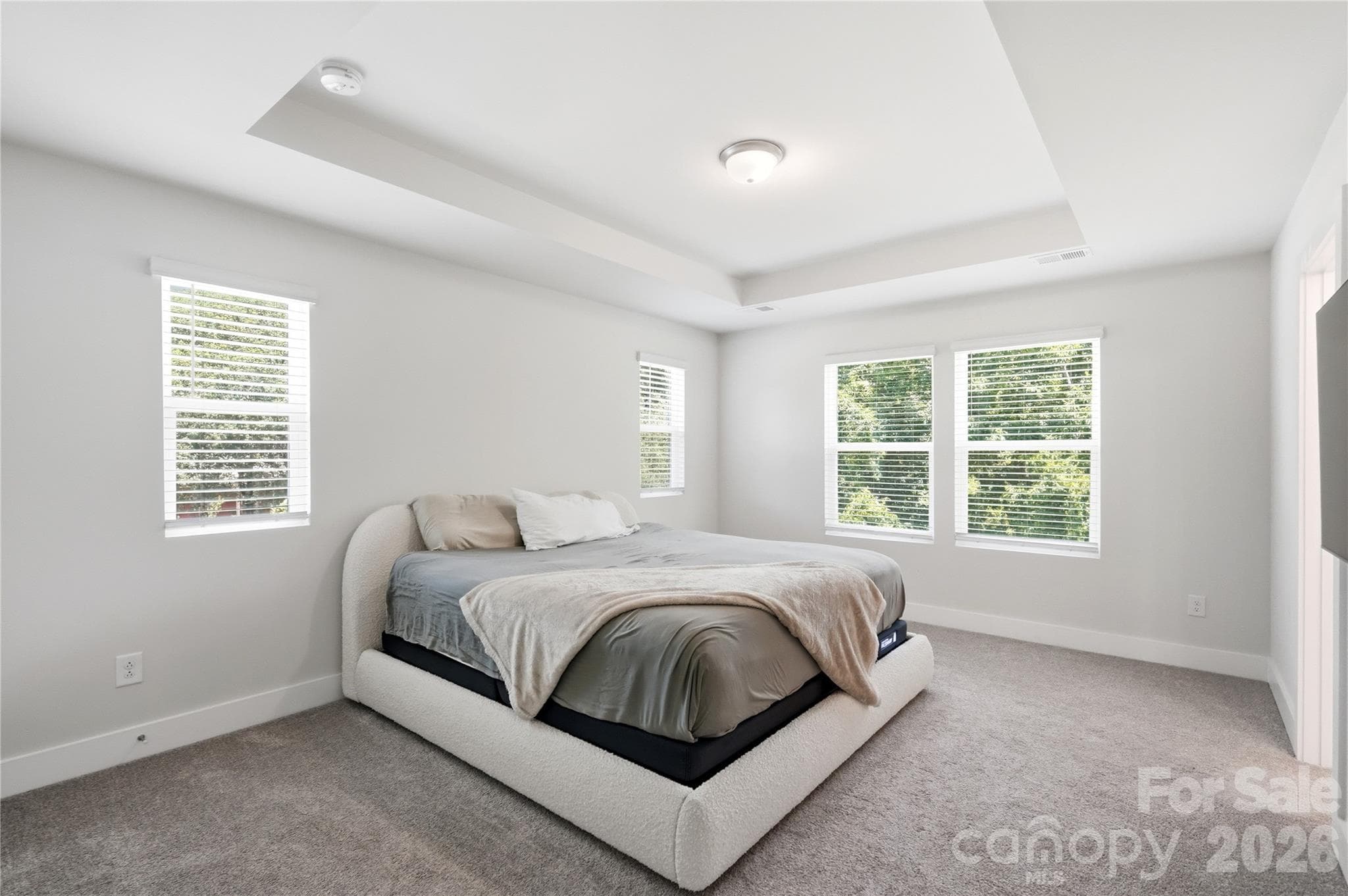 Spacious primary bedroom with tray ceiling and en suite bathroom - 3324 Treble Court, Charlotte