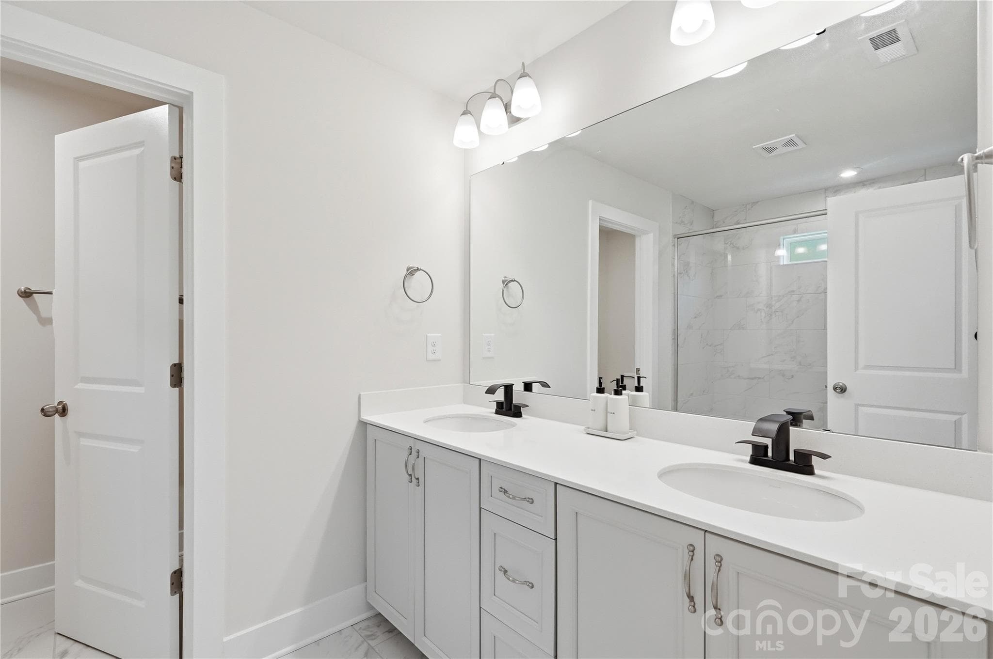 Primary en suite bathroom with dual sinks, upgraded black faucets and shower head [2023] - 3324 Treble Court, Charlotte
