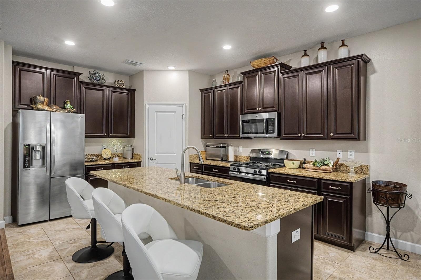 Espresso cabinets with crown molding, granite center island and counters and upgraded appliances in the gourmet kitchen! - 4926 SOUTHERN VALLEY LOOP, BROOKSVILLE