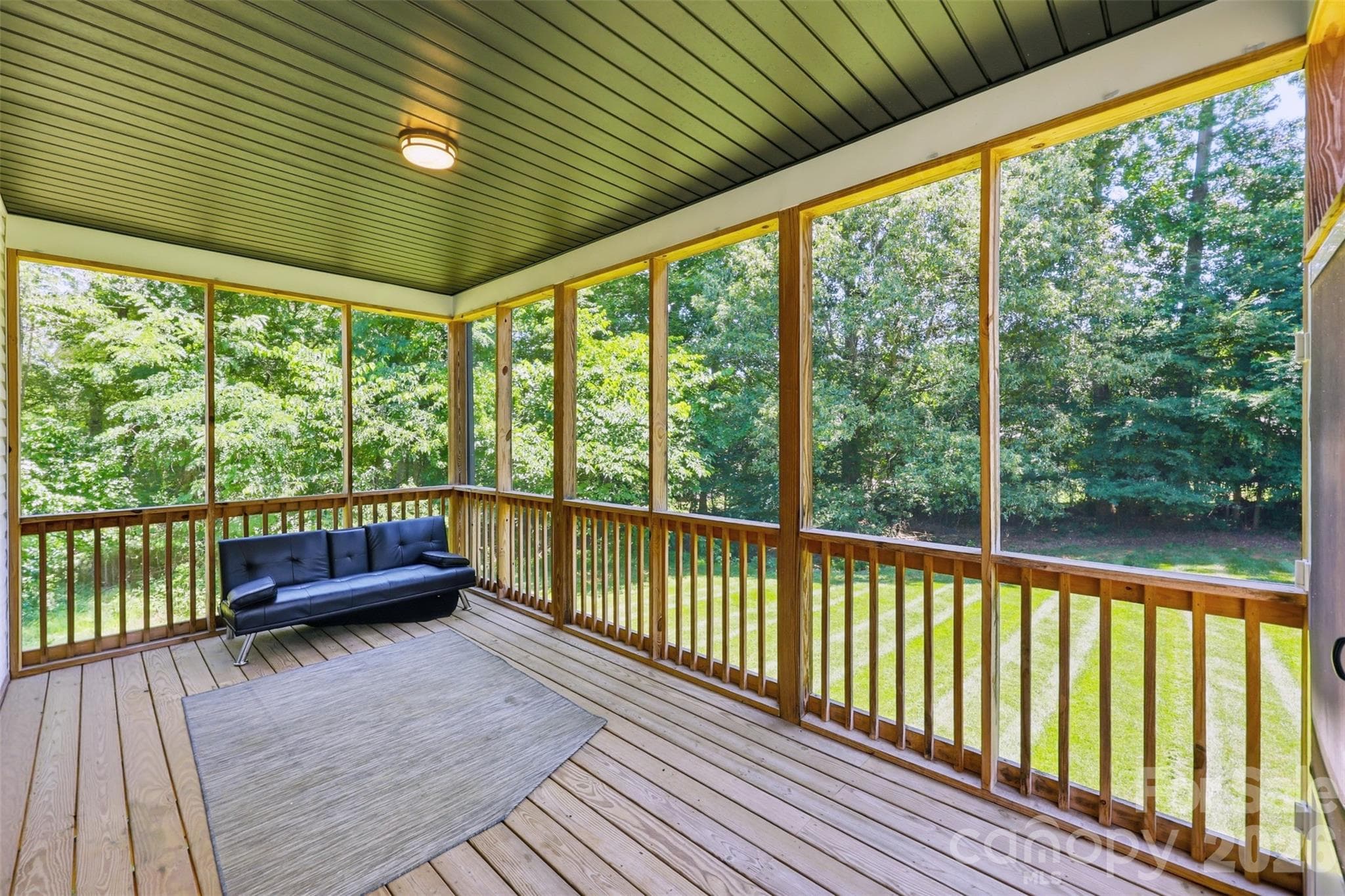 Covered, screened deck overlooks spacious backyard with wooded view. - Rock Hill