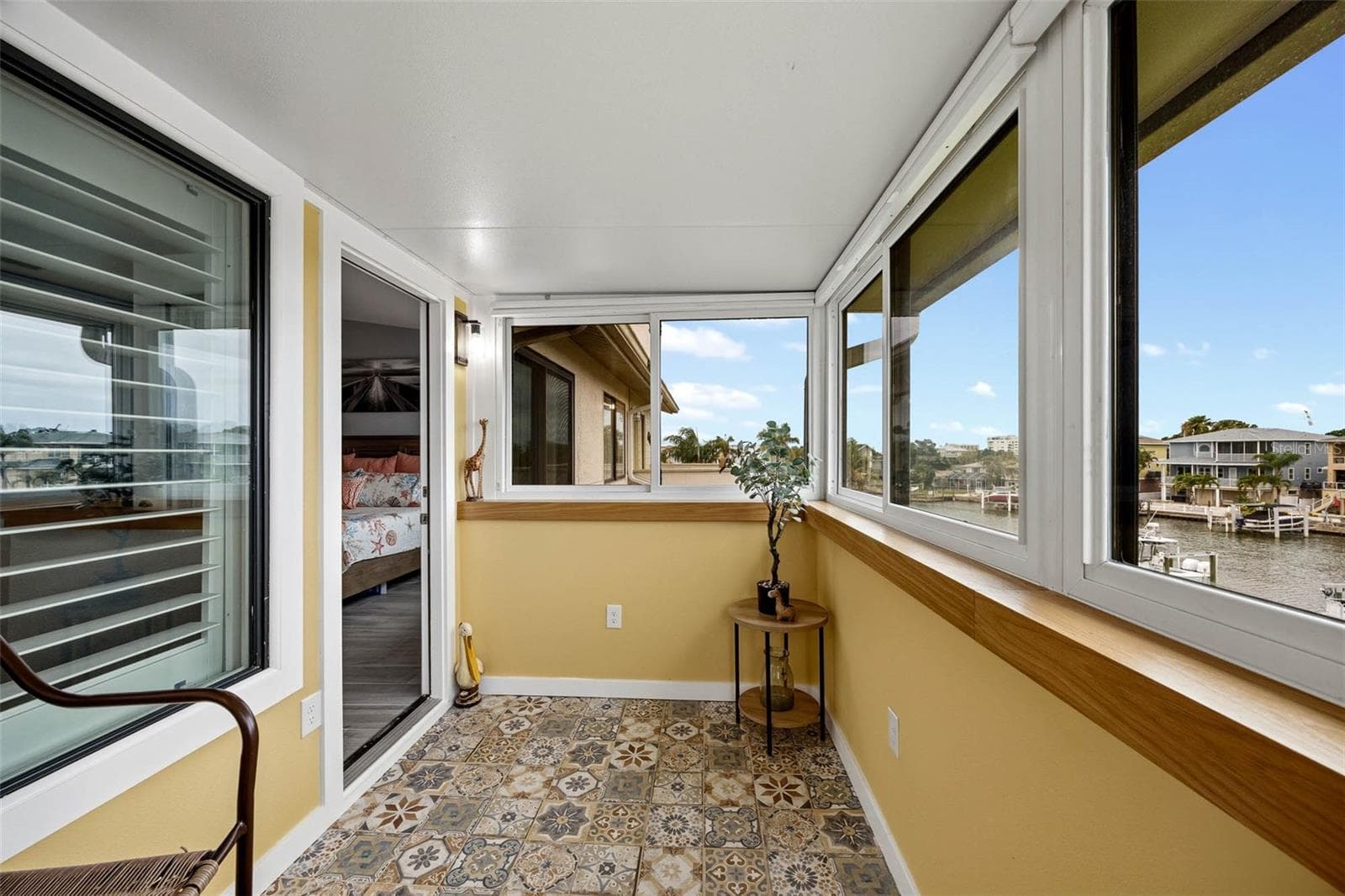 Balcony off of the Primary Suite with newer insulated roof and hurricane windows and gorgeous custom tile flooring. - 2395 HANOVER DR, DUNEDIN