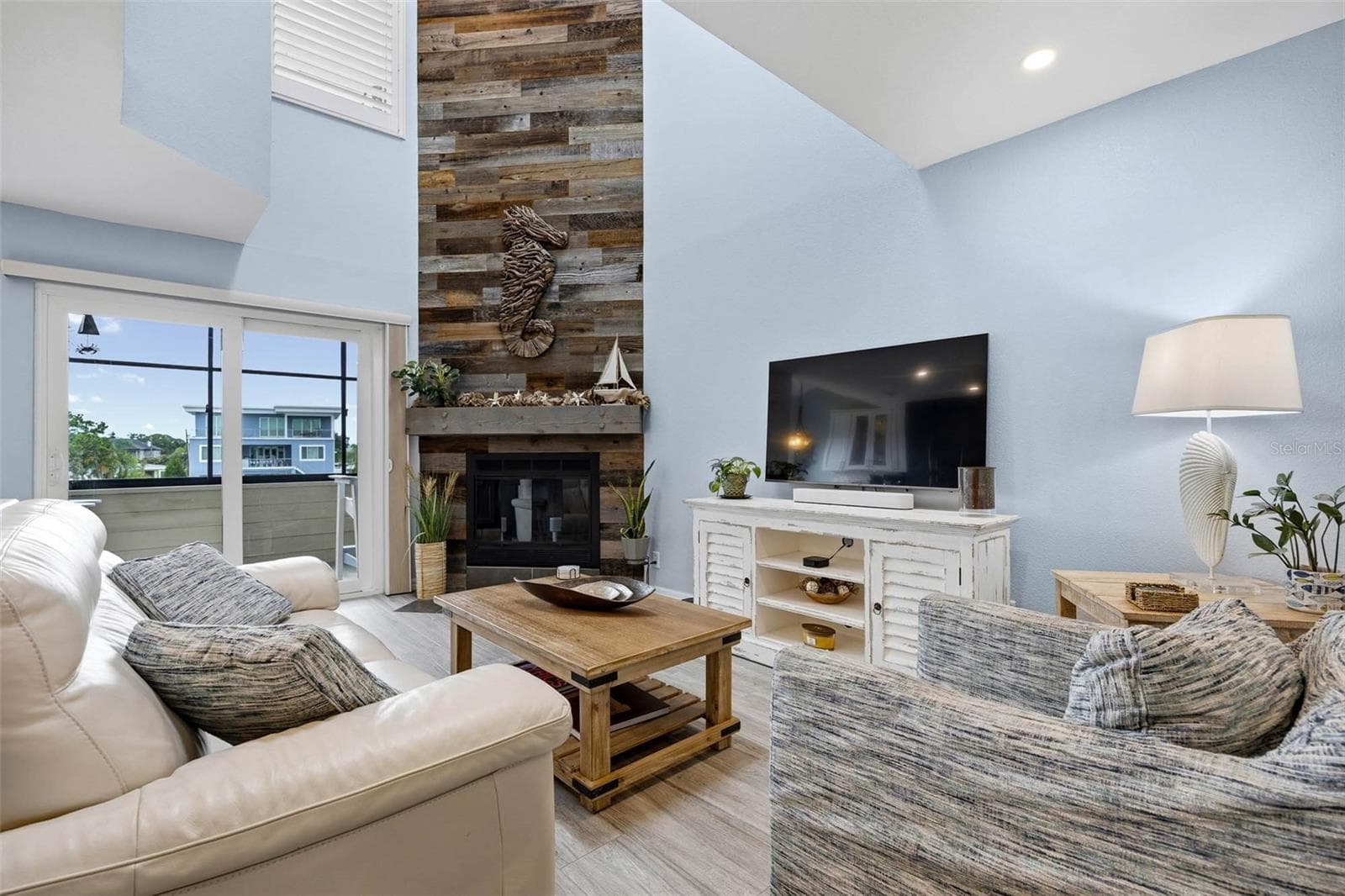 Main floor Living Room with vaulted ceiling and impressive fireplace with wood accent wall. - 2395 HANOVER DR, DUNEDIN