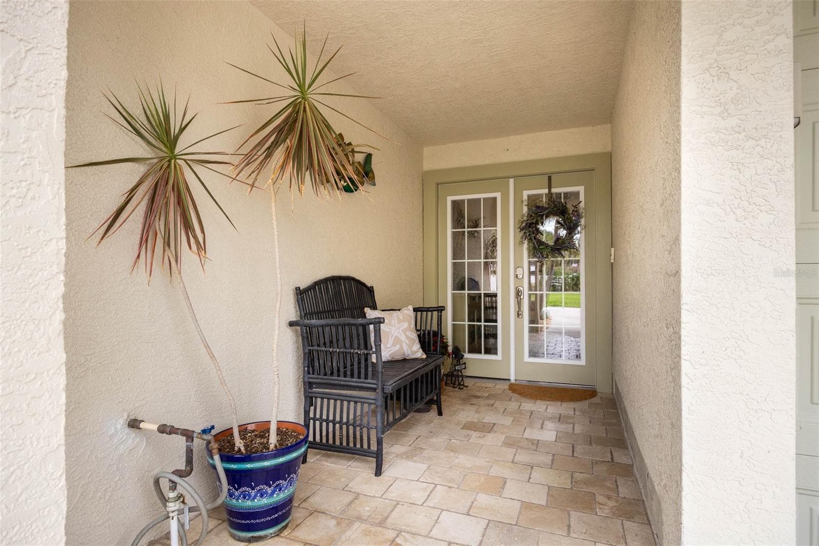 Main Entrance with lovely covered patio finished with travertine. - 2395 HANOVER DR, DUNEDIN
