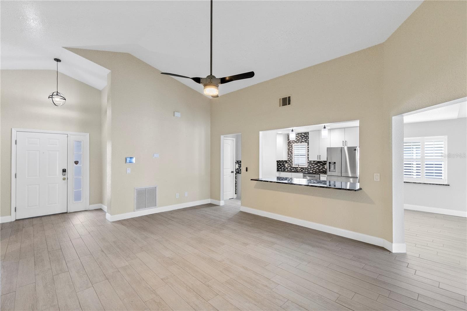 Living room off Front entry overlooking kitchen and dining area - 10057 SANDBAR ST, ORLANDO