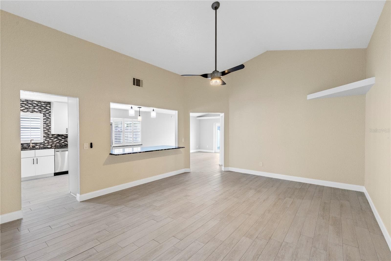 Living room off Front entry overlooking kitchen and dining area - 10057 SANDBAR ST, ORLANDO