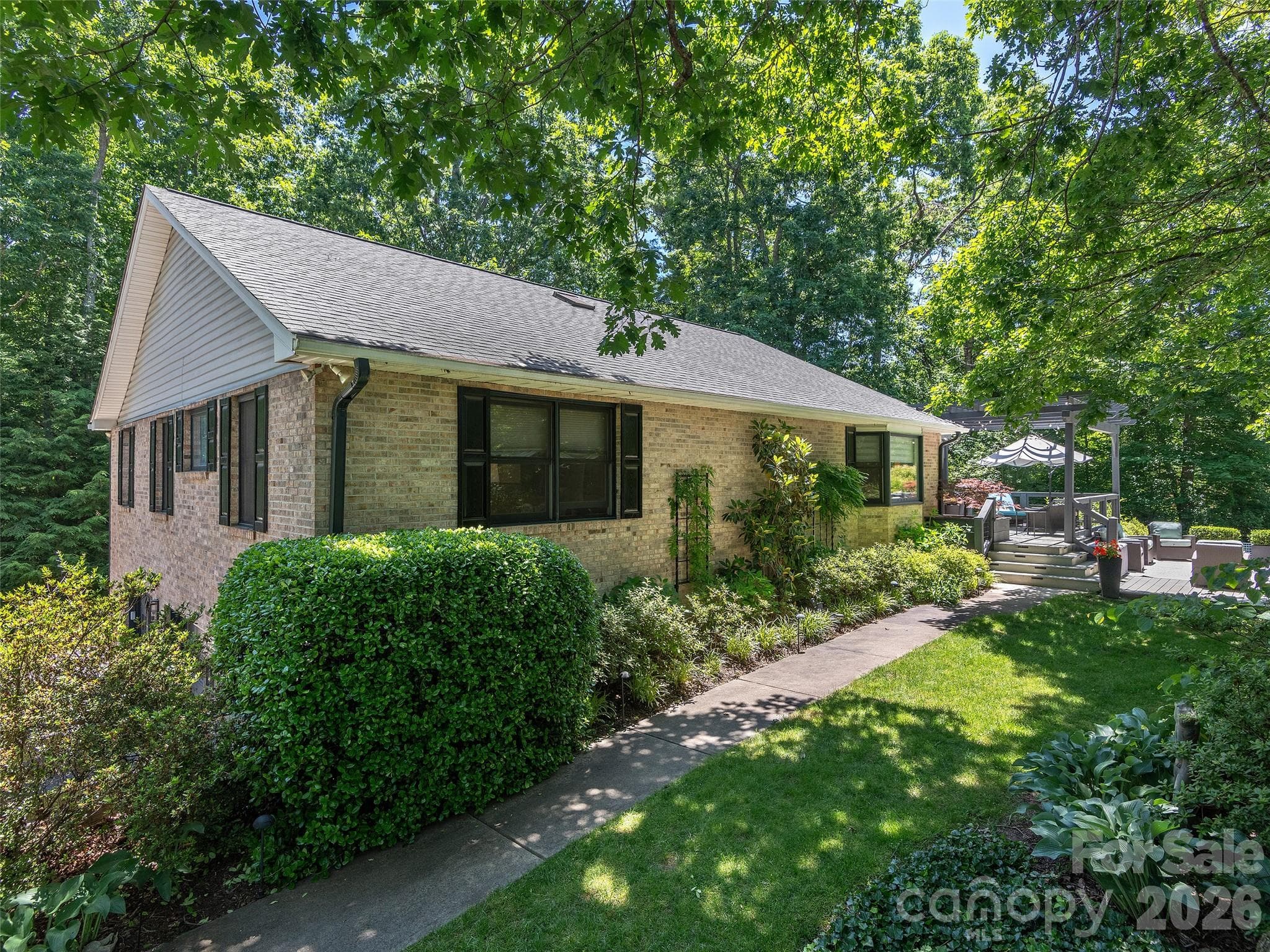 Classic brick home set within professionally designed gardens, showcasing years of thoughtful landscaping and exceptional curb appeal - Hendersonville