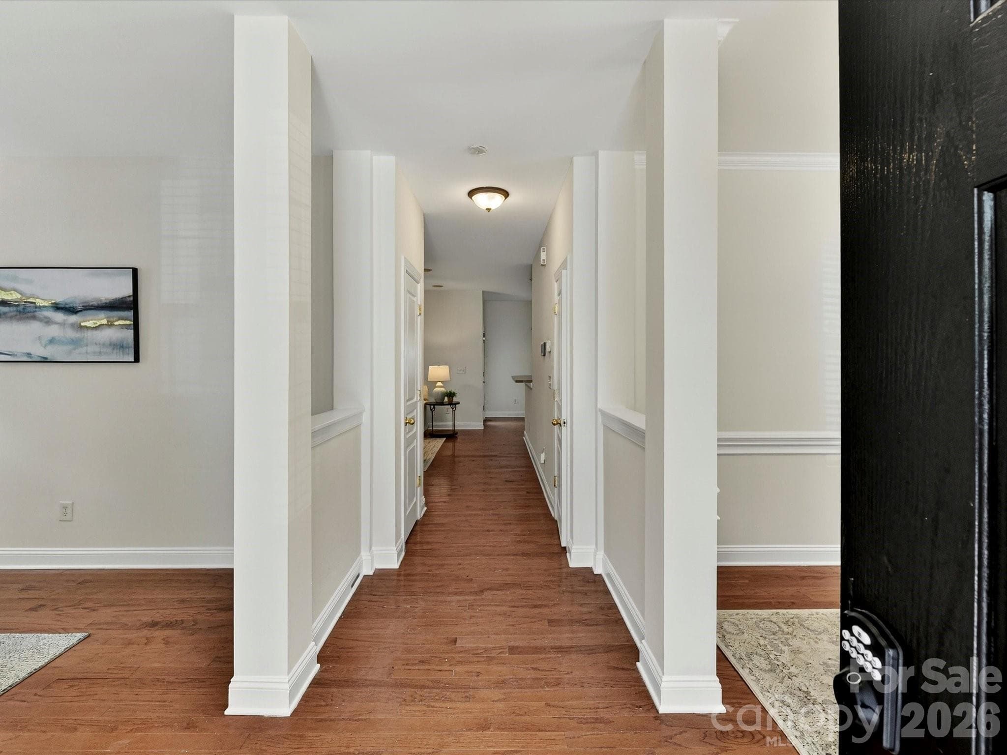 Inviting entryway features wood flooring, elegant column accents, and an open layout that creates a warm and welcoming first impression. - Cornelius