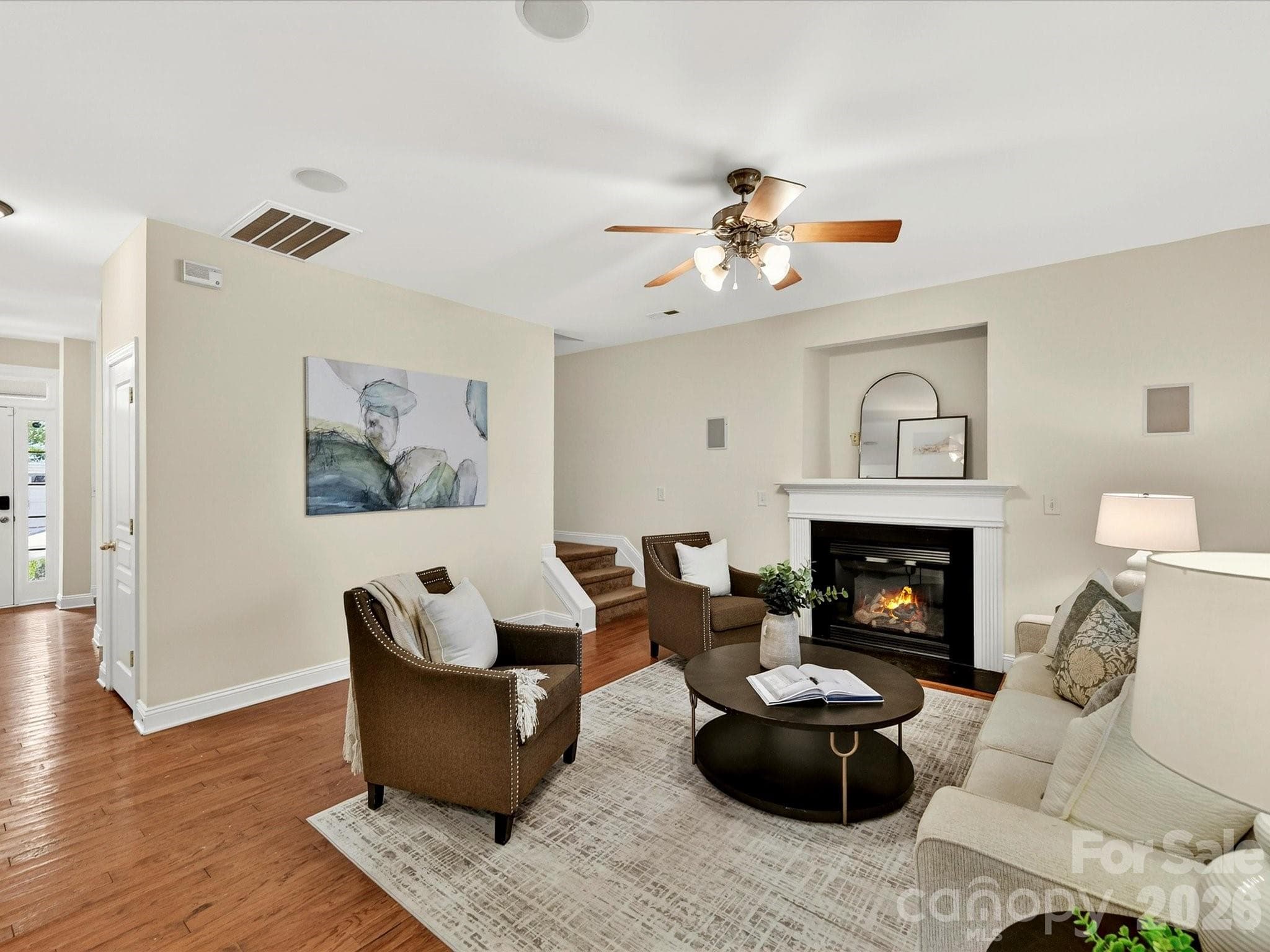 Inviting family room offers generous gathering space, warm wood flooring, abundant natural light, and a beautiful fireplace that serves as the focal point of the room. - Cornelius