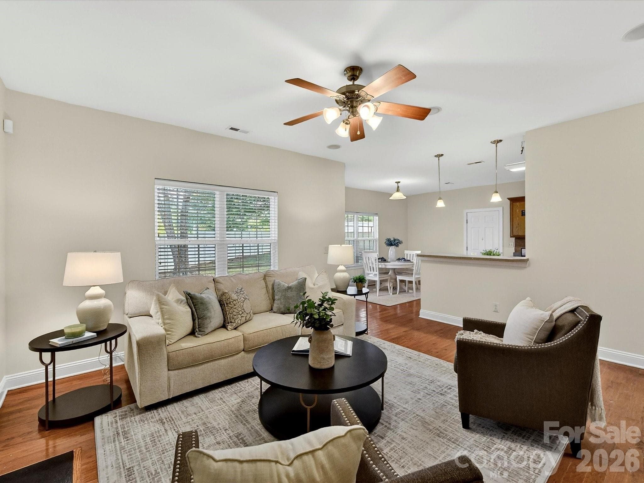 Inviting family room offers generous gathering space, warm wood flooring, abundant natural light, and a beautiful fireplace that serves as the focal point of the room. - Cornelius