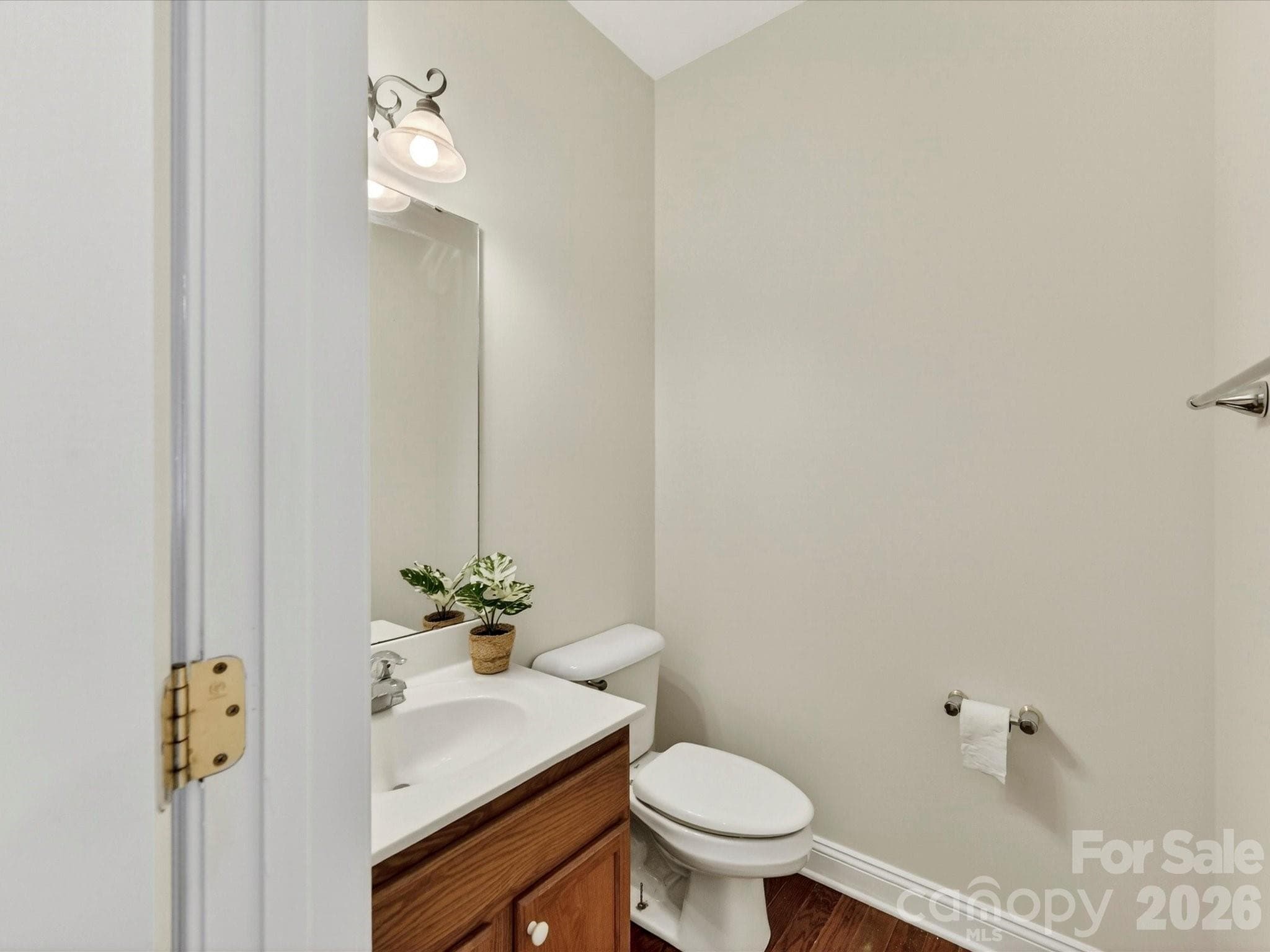 Convenient main-level powder room features a pedestal-style vanity area and is ideally located for guests and everyday use. - Cornelius