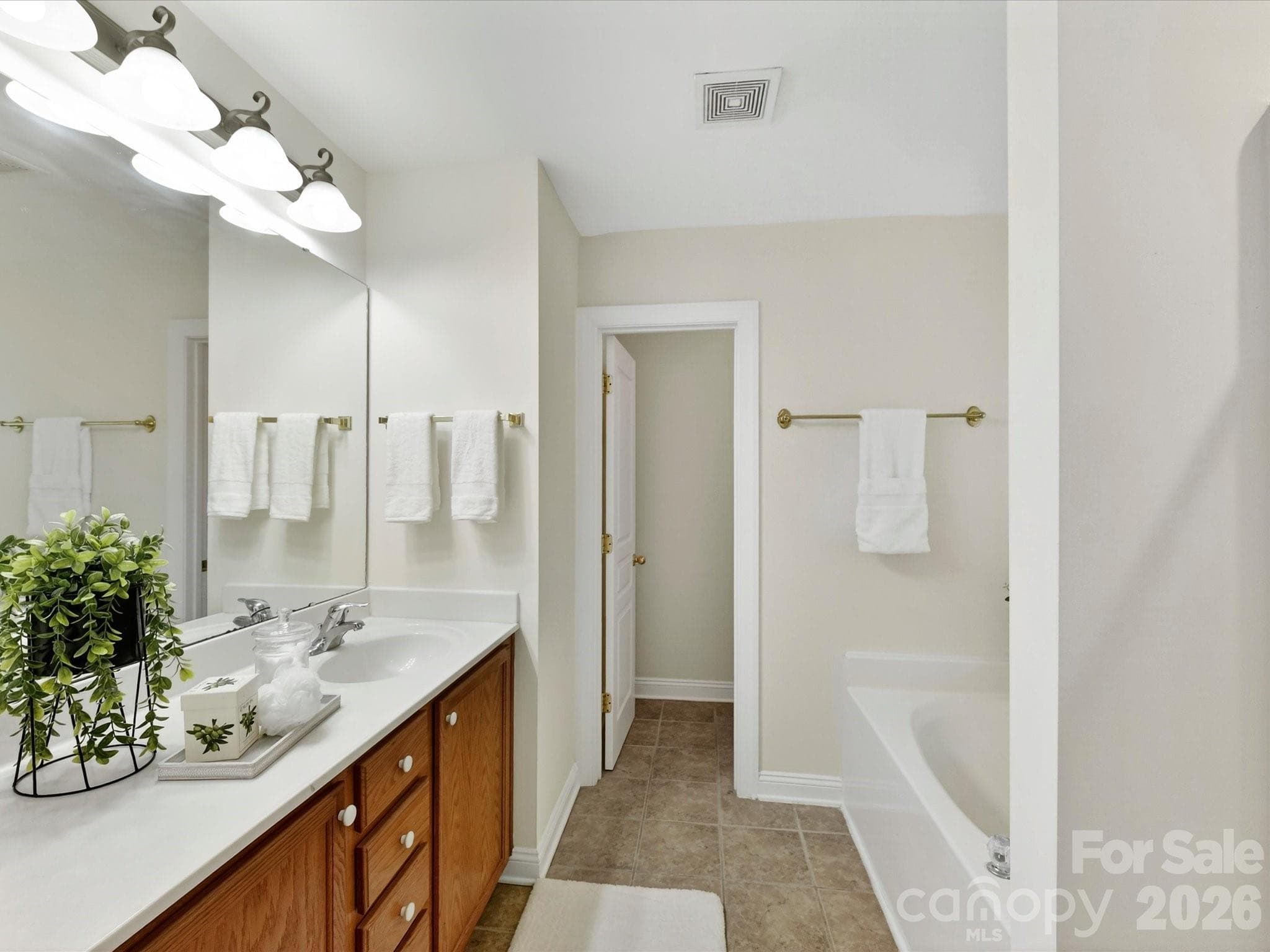 Primary bathroom features a dual-sink vanity, relaxing garden tub, separate shower, and generous space designed for comfort and everyday convenience. - Cornelius